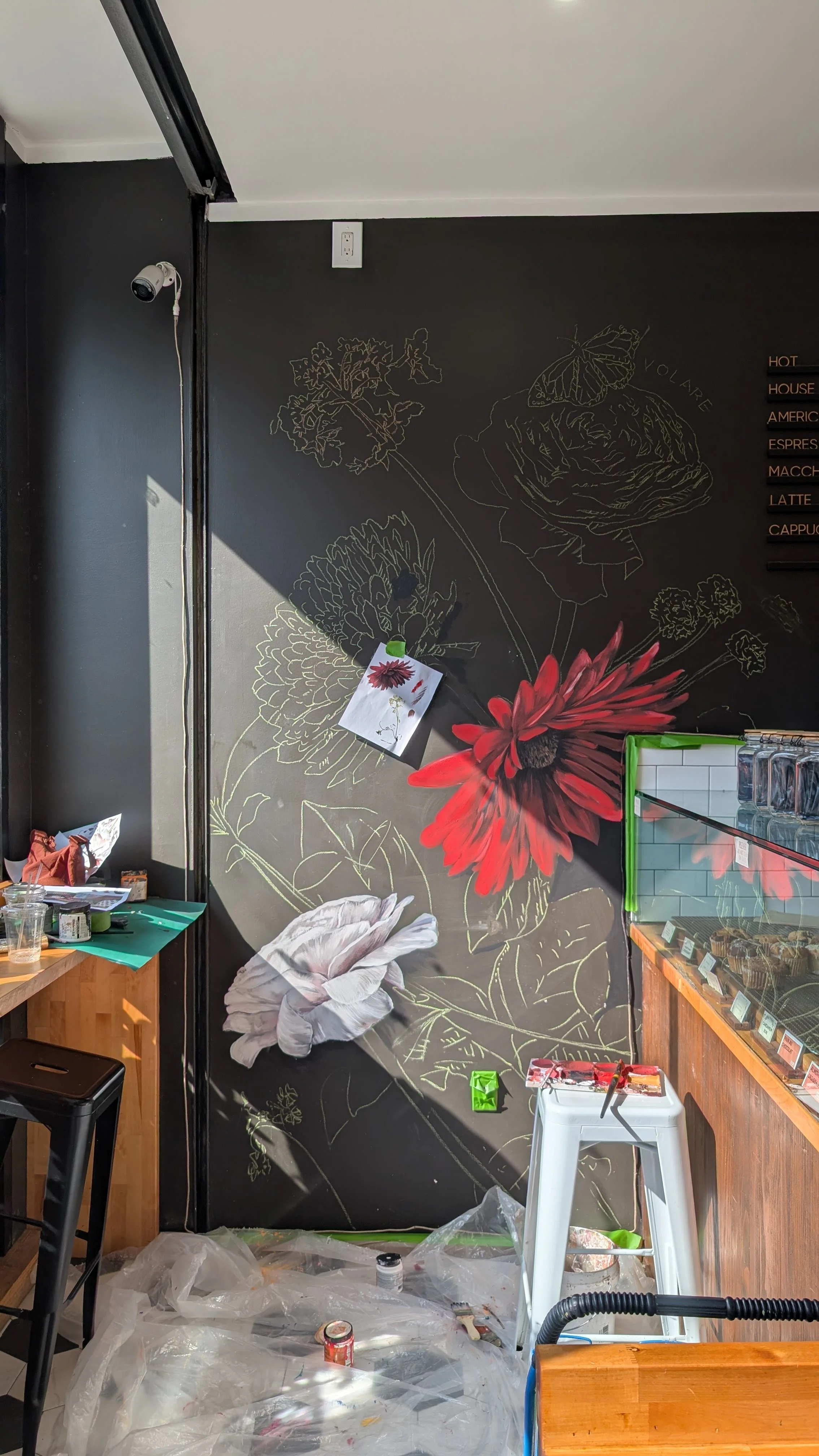 Process shot of two rose and gerbera hand-painted on wall 