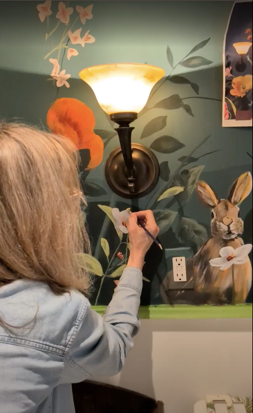 Grandma painting the bee on the wall