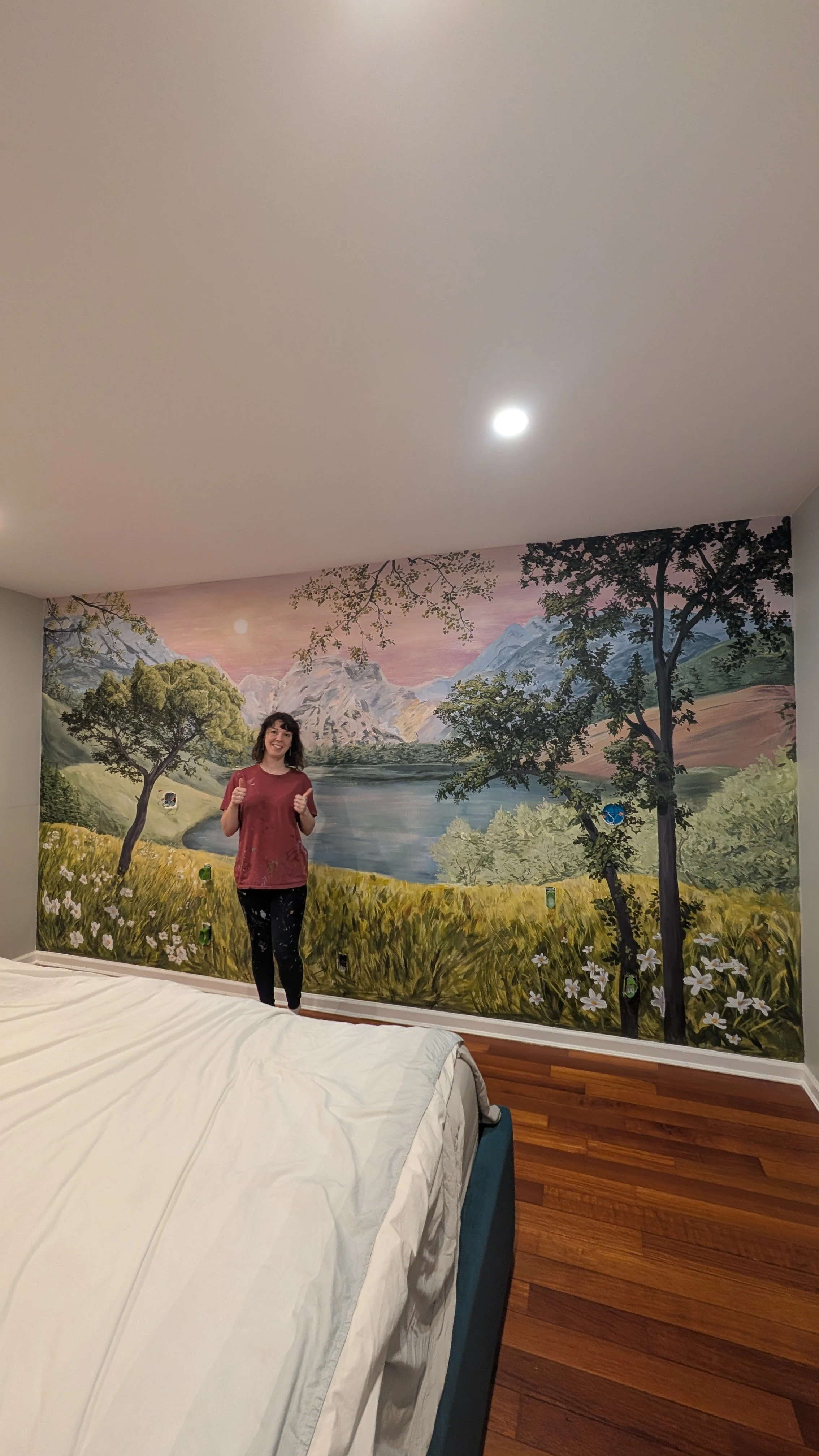 brooklyn mural artist poses in front of mountain mural