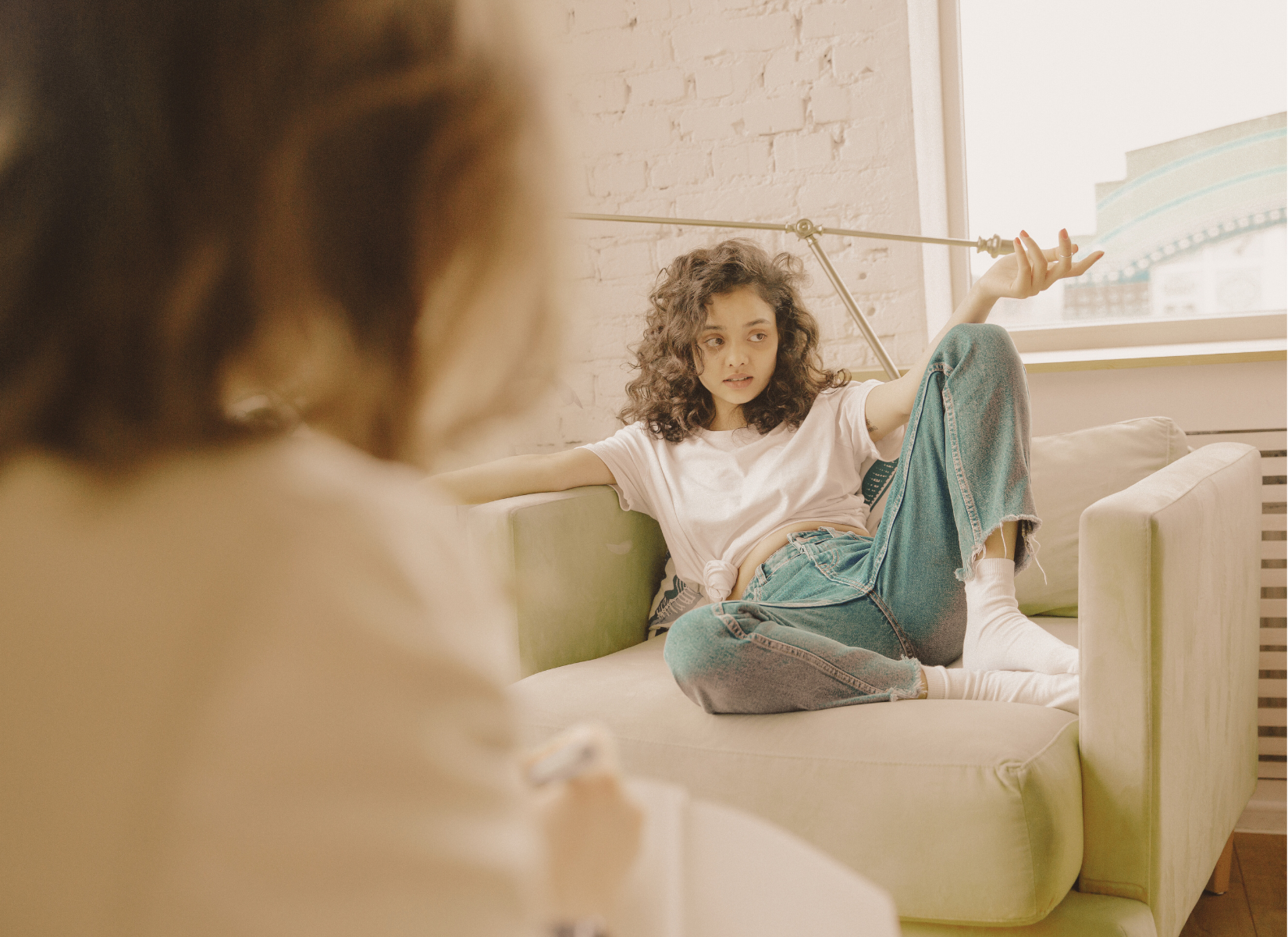 Young client talking with a therapist while sitting on a couch