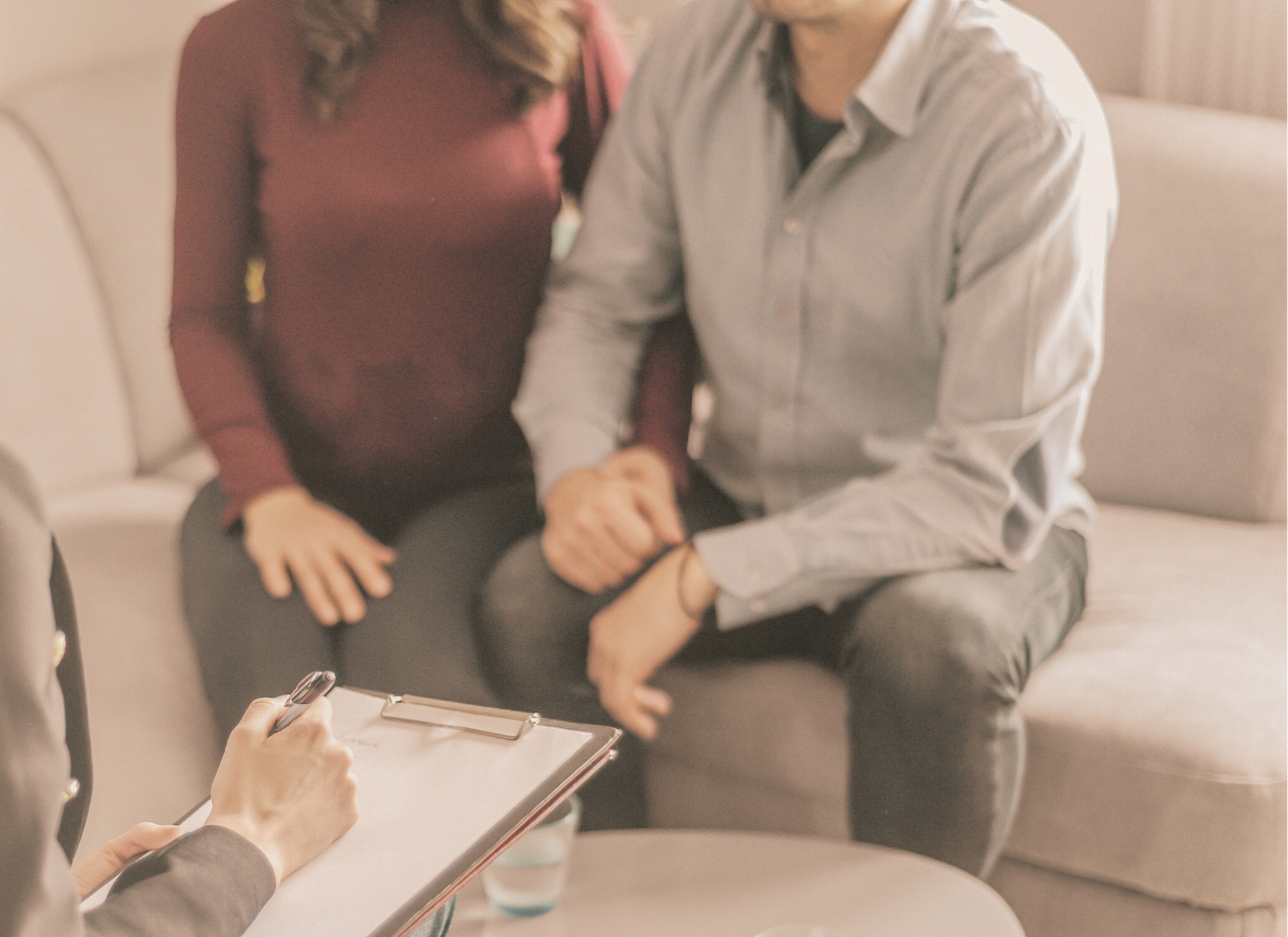 Therapist taking notes while meeting with a couple during a counseling session