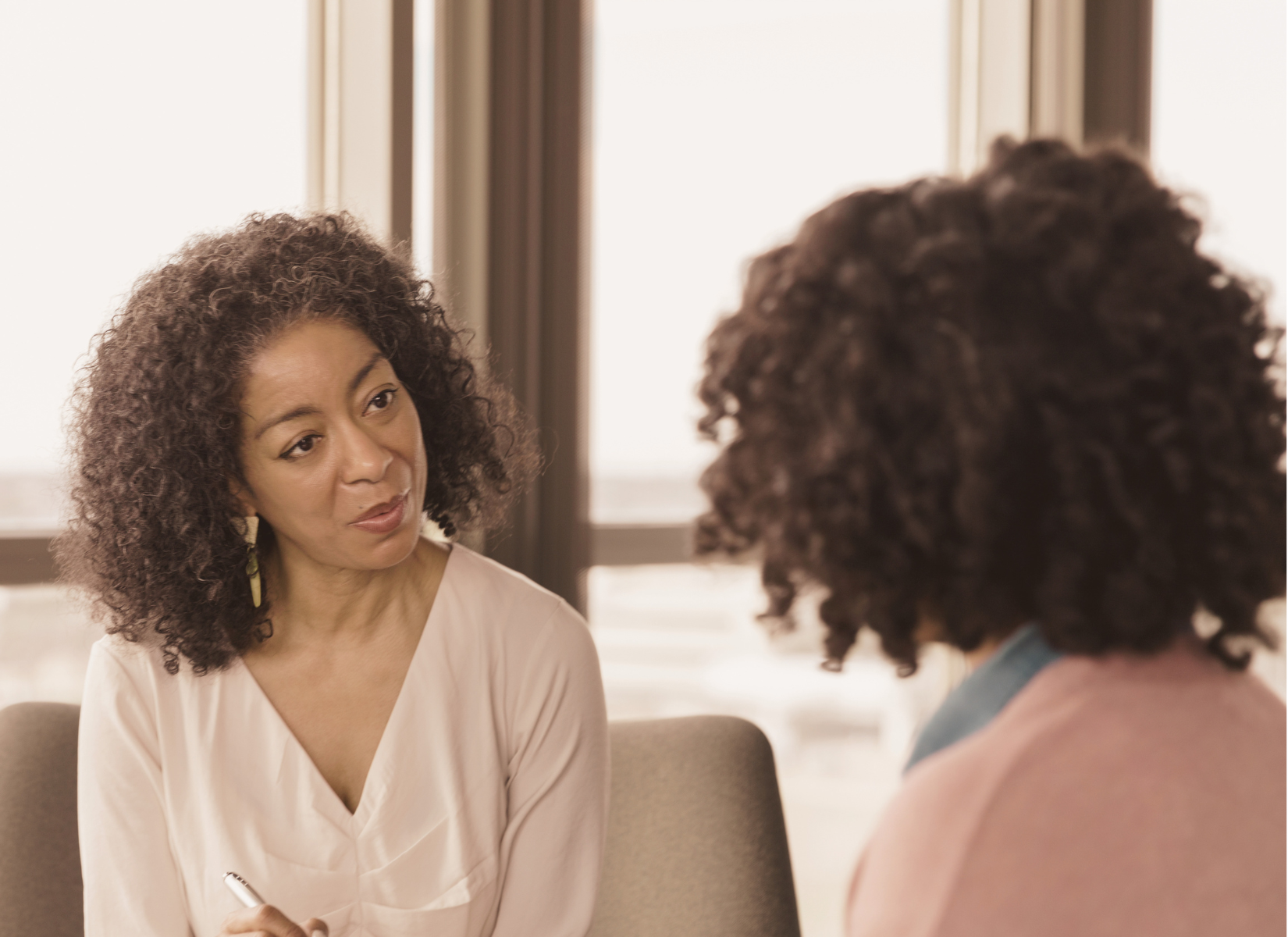 BIPOC Therapist listening attentively to a client during a counseling session