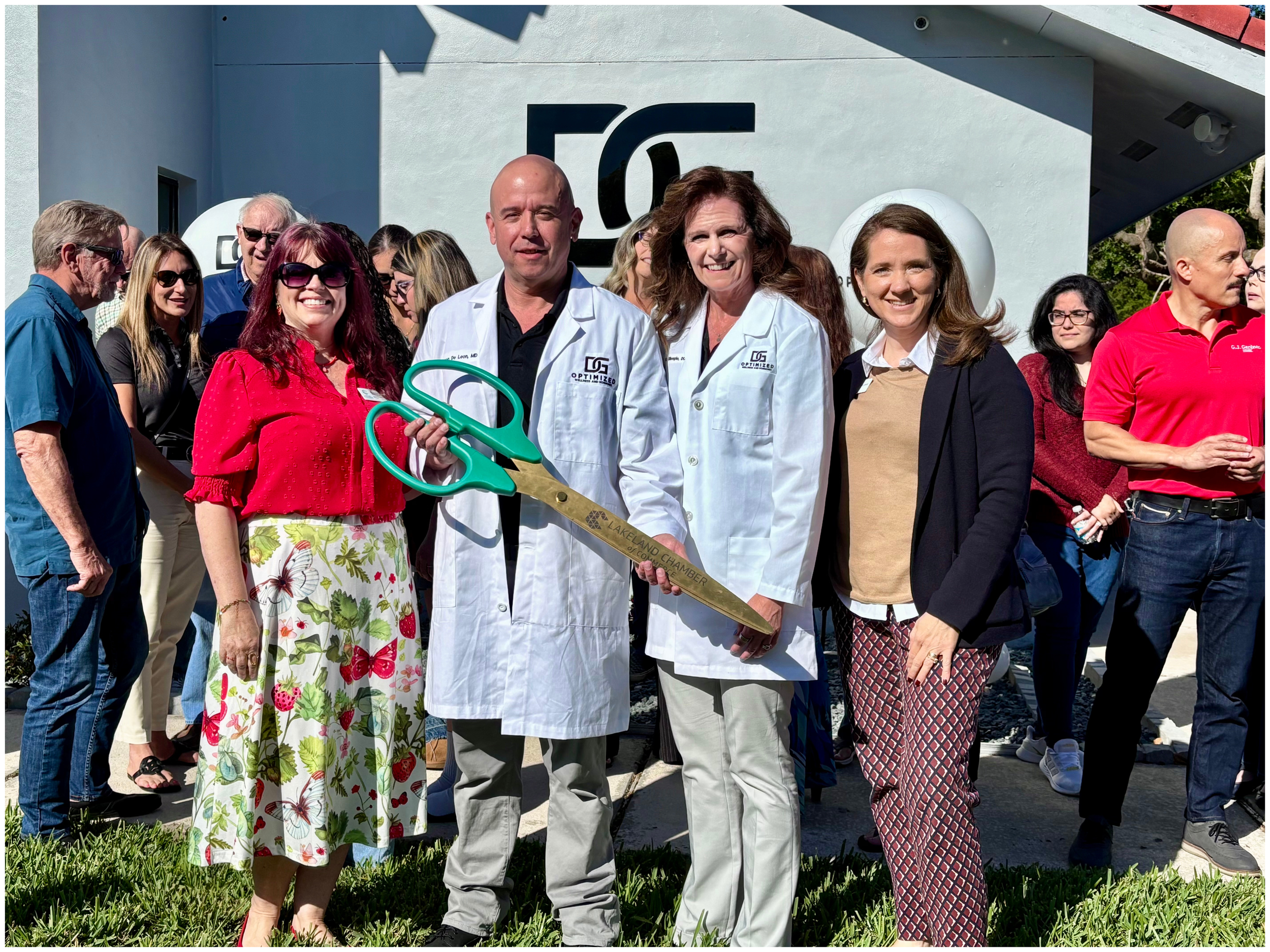 Dr. De Leon and Dr. Gillespie and guest with ribbon cutting scissors.