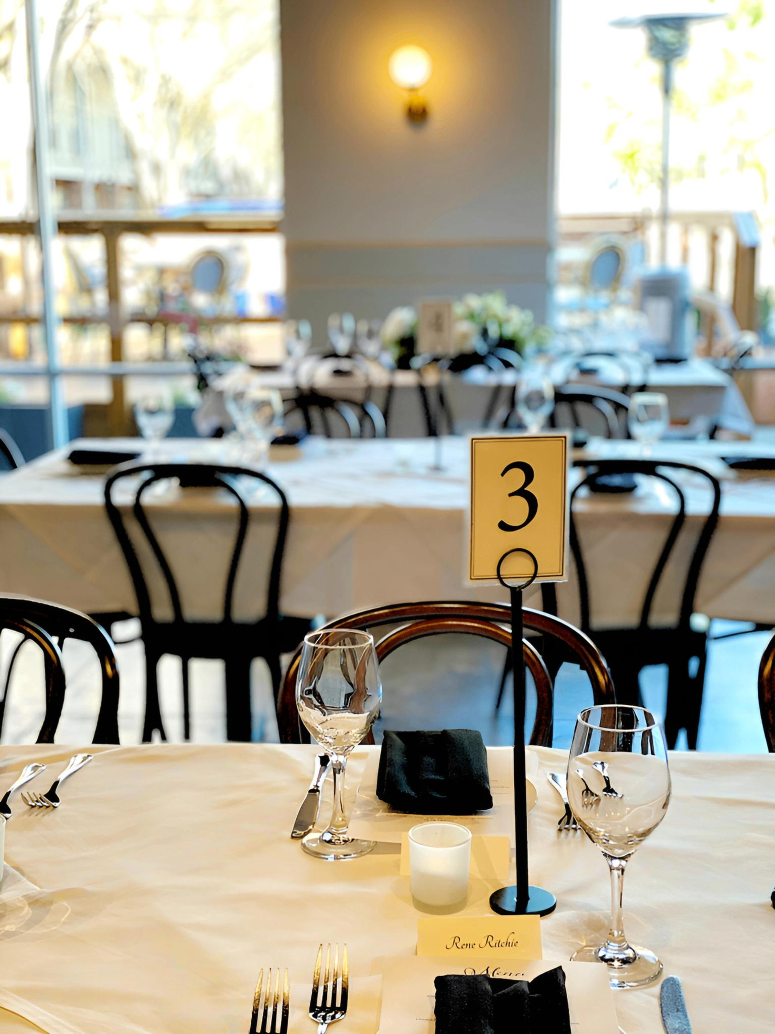Eliza’s outdoor deck set with white tablecloths and bistro chairs for a group celebration in Baton Rouge