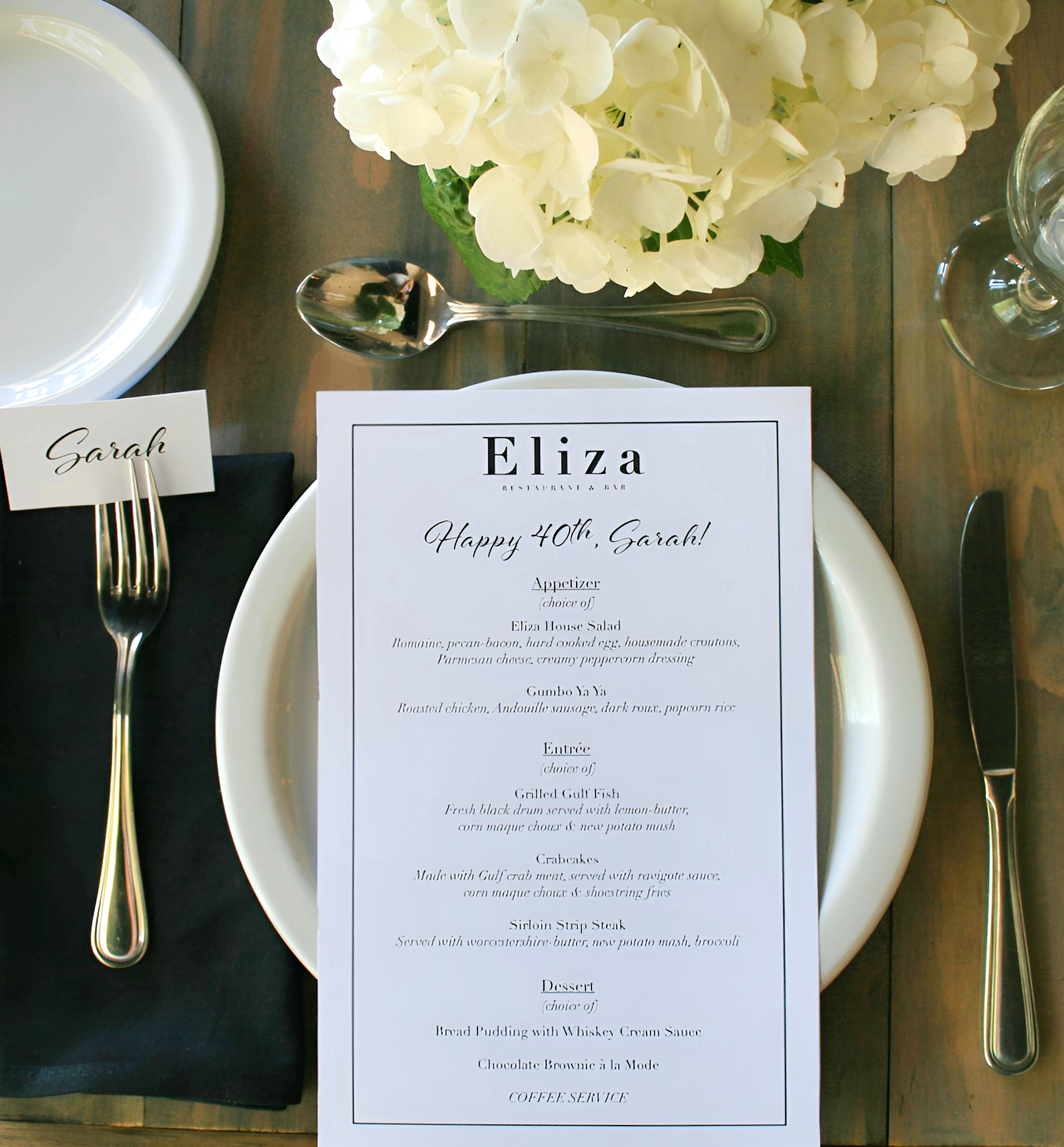 Long candlelit table set with wine glasses and fresh flowers for a private dinner at Eliza in Baton Rouge