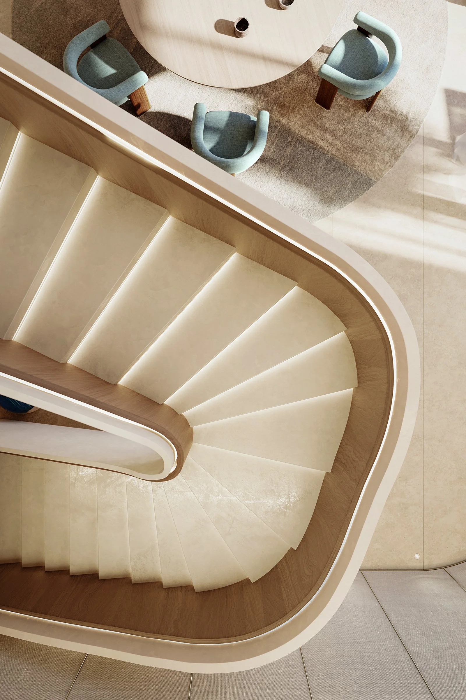 Top-down view of a staircase with curved wooden handrail, white steps, and beige tile floor at the bottom. The staircase is seen from above, overlooking a round table with three chairs around it, and an area with a beige rug.