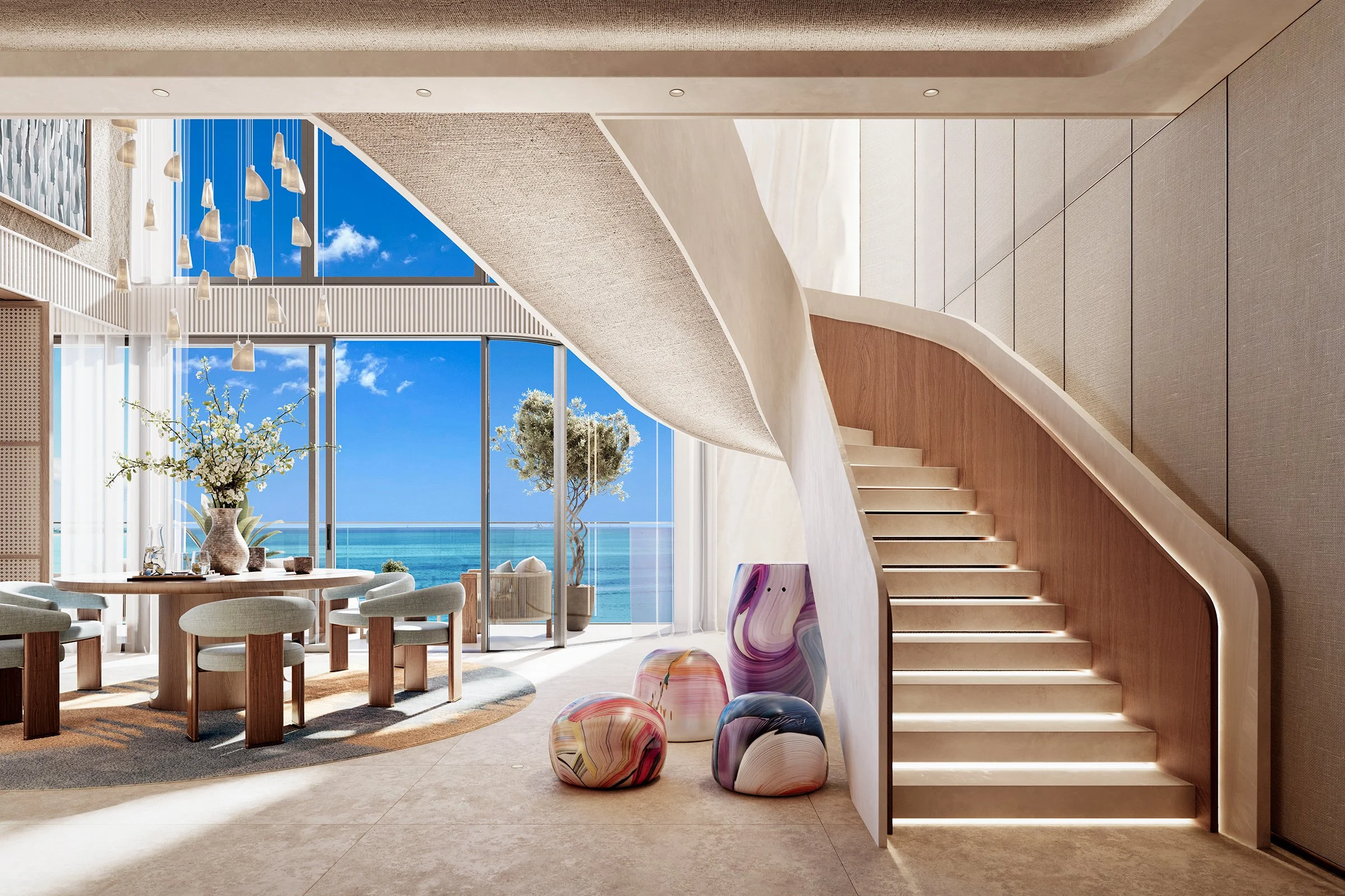 Modern interior of a house with staircase, large windows showing ocean view, dining area with a round table, flowers, and colorful abstract stools.