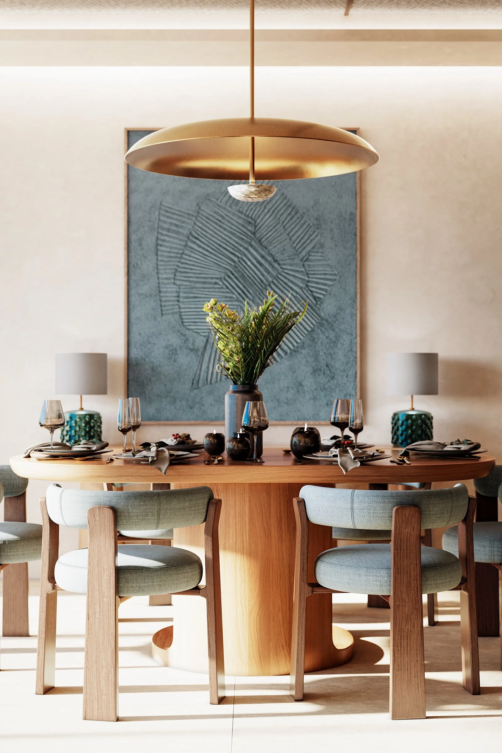 Dining room with a wooden table set with plates, glasses, and black vases. A large golden pendant light hangs above, and a blue textured abstract artwork decorates the wall behind. A tall plant centerpiece is on the table, with two small white lamps on either side.