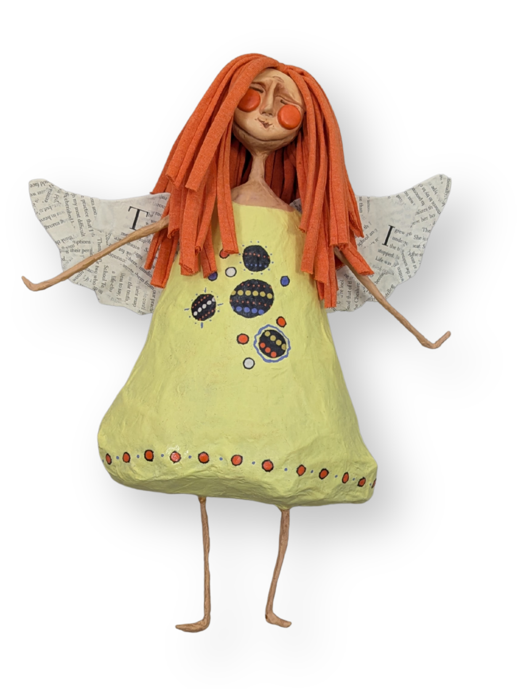 Finished papier-mâché angel with orange fabric hair, paper wings, and a yellow painted dress.