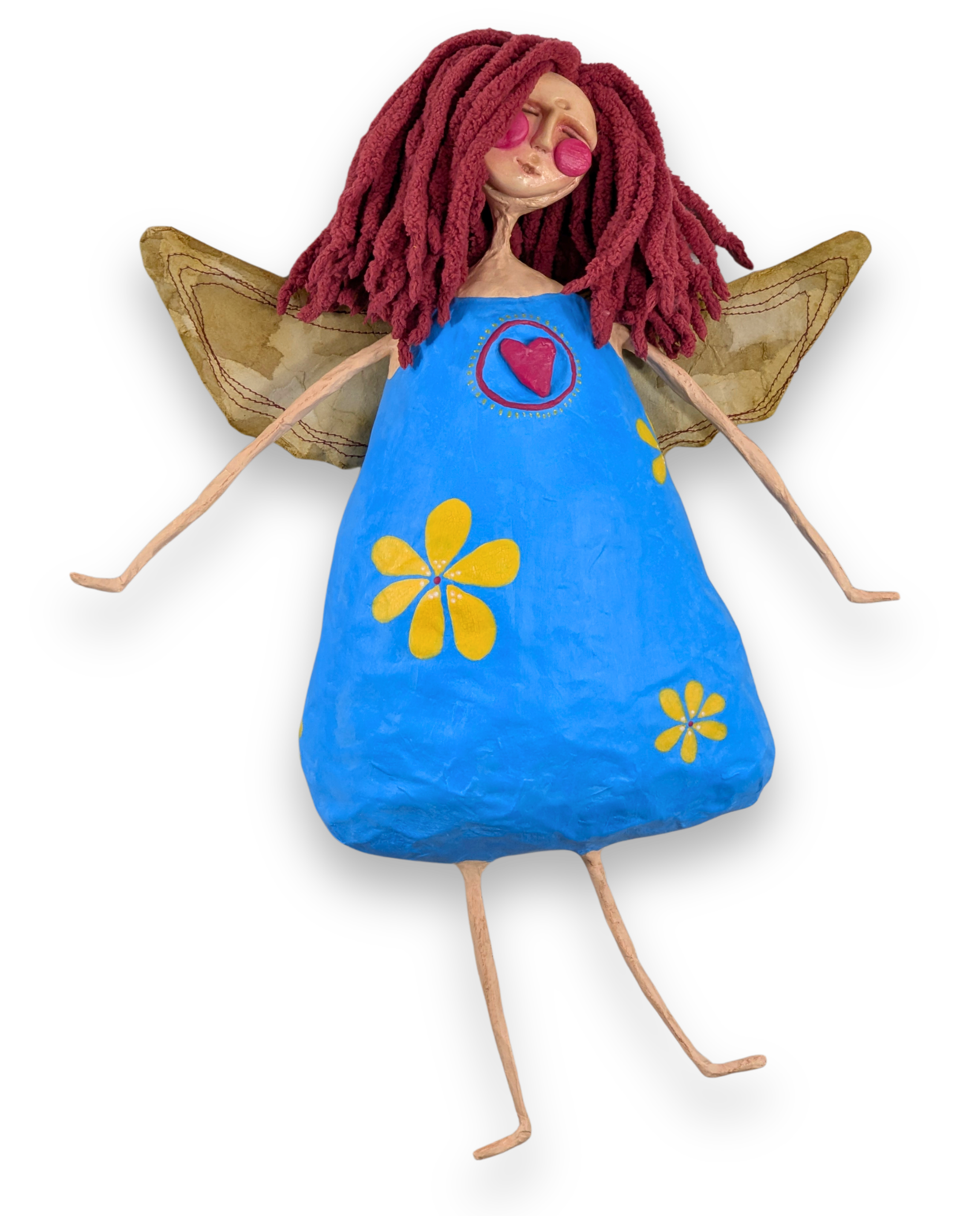 Pippa, a handmade papier-mâché angel with reddish-purple hair, a bright blue dress with yellow flowers and golden wings.
