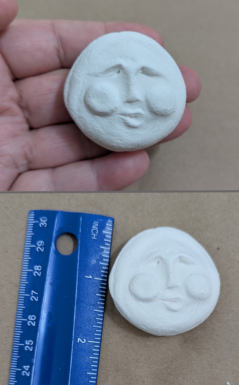Two-photo image of a medium handmade paper-clay starter face with closed eyes and a gentle smile, shown held in hand above and beside a ruler below for size reference.