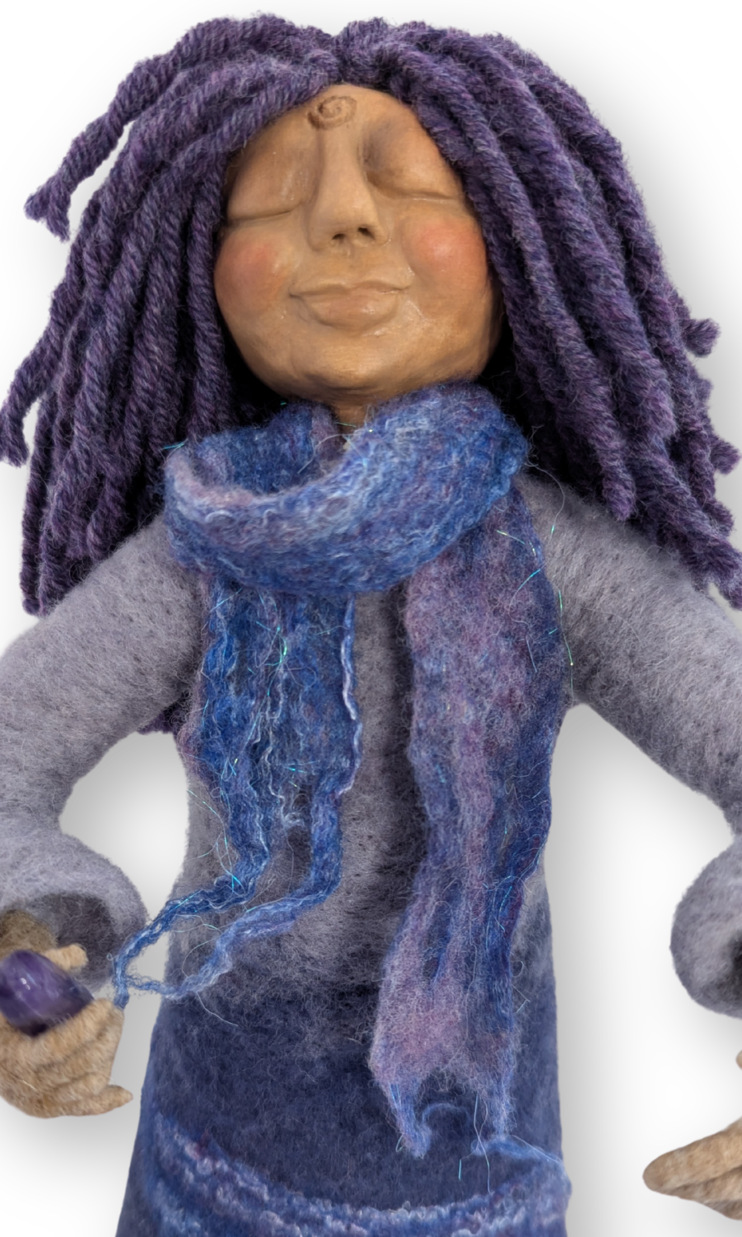 Close-up of Priestess Guardian Doll’s serene face and blue-purple wool scarf