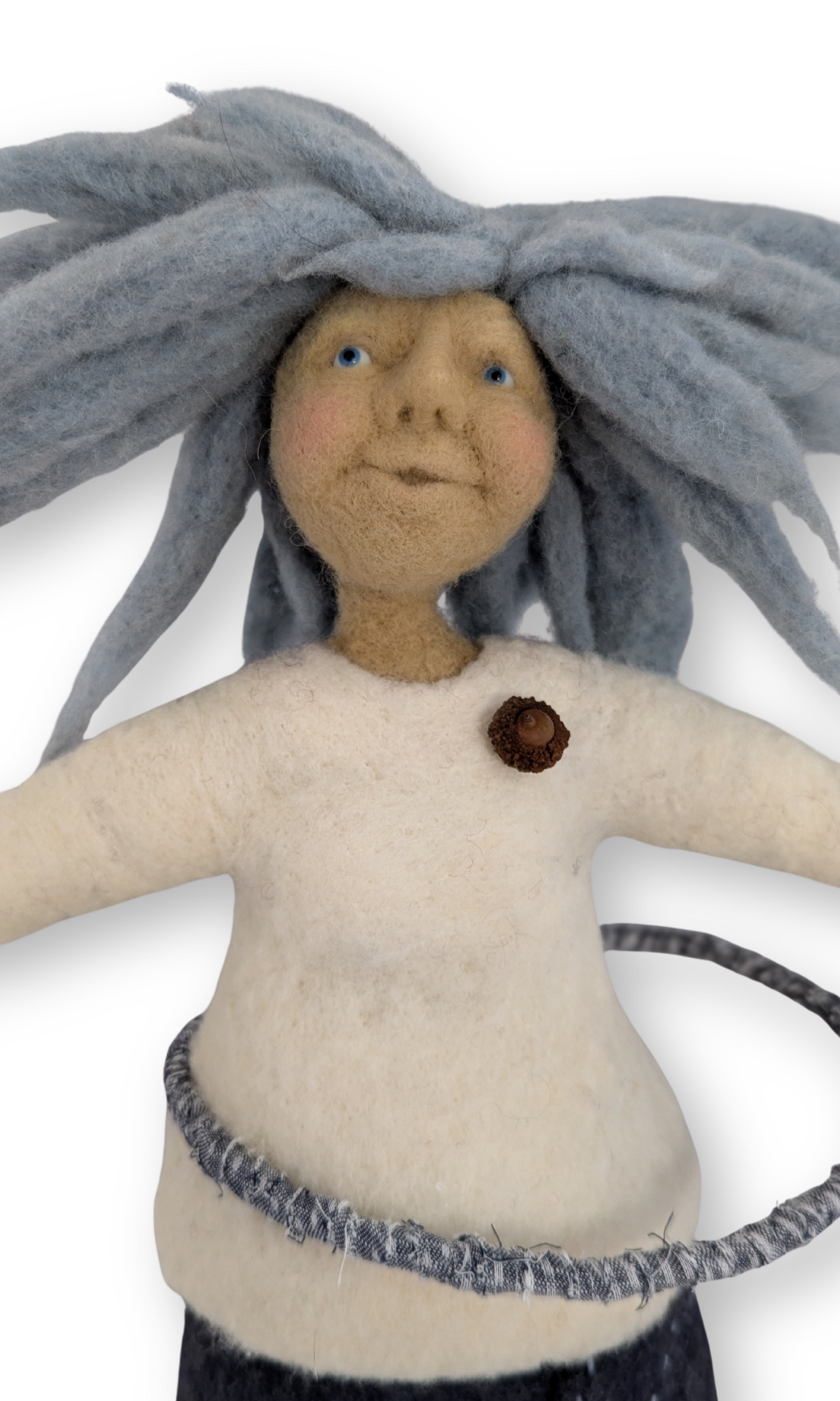 Close-up of hula hoop guardian doll’s face with blue felted hair and acorn detail.