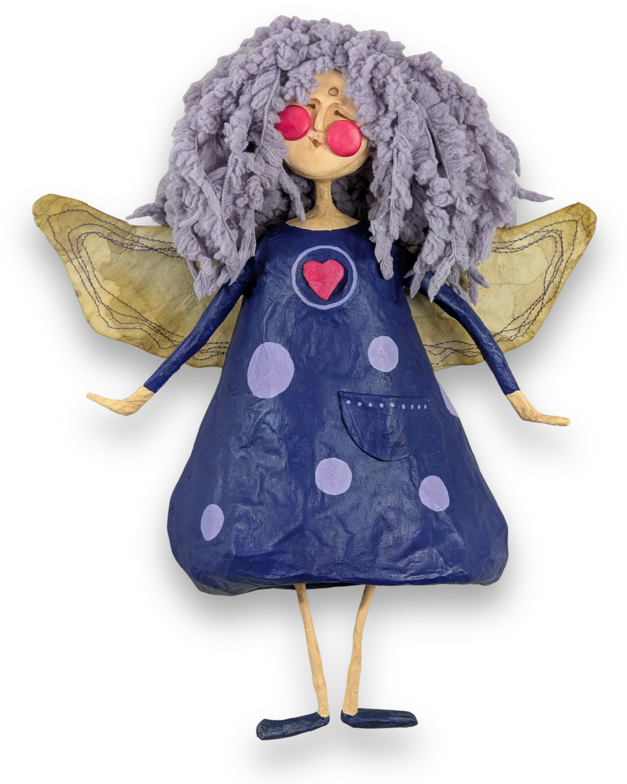 Willa, a handmade papier-mâché angel with lavender curls, a navy polka-dot dress with a pocket, golden wings and small dark shoes.
