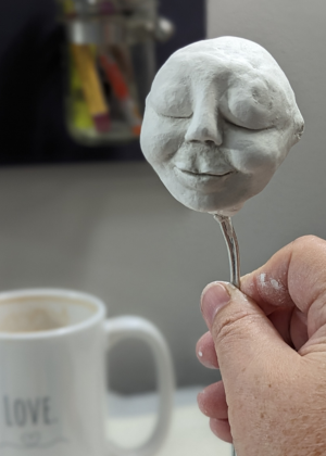 Close-up of a sculpted clay face used for a handmade spirit doll.