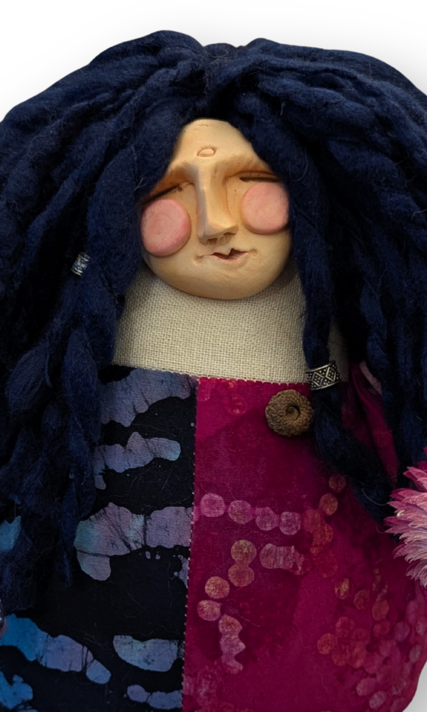 Close-up of The Laughing Poppet’s clay face with rosy cheeks and joyful expression — handmade spirit doll.