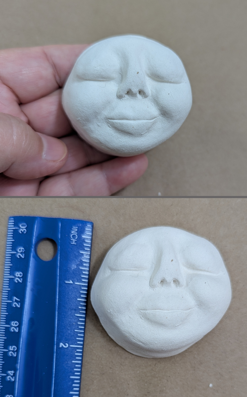 Two-photo image of a medium handmade paper-clay starter face with rounded cheeks and closed eyes, shown held in hand above and beside a ruler below for size reference.