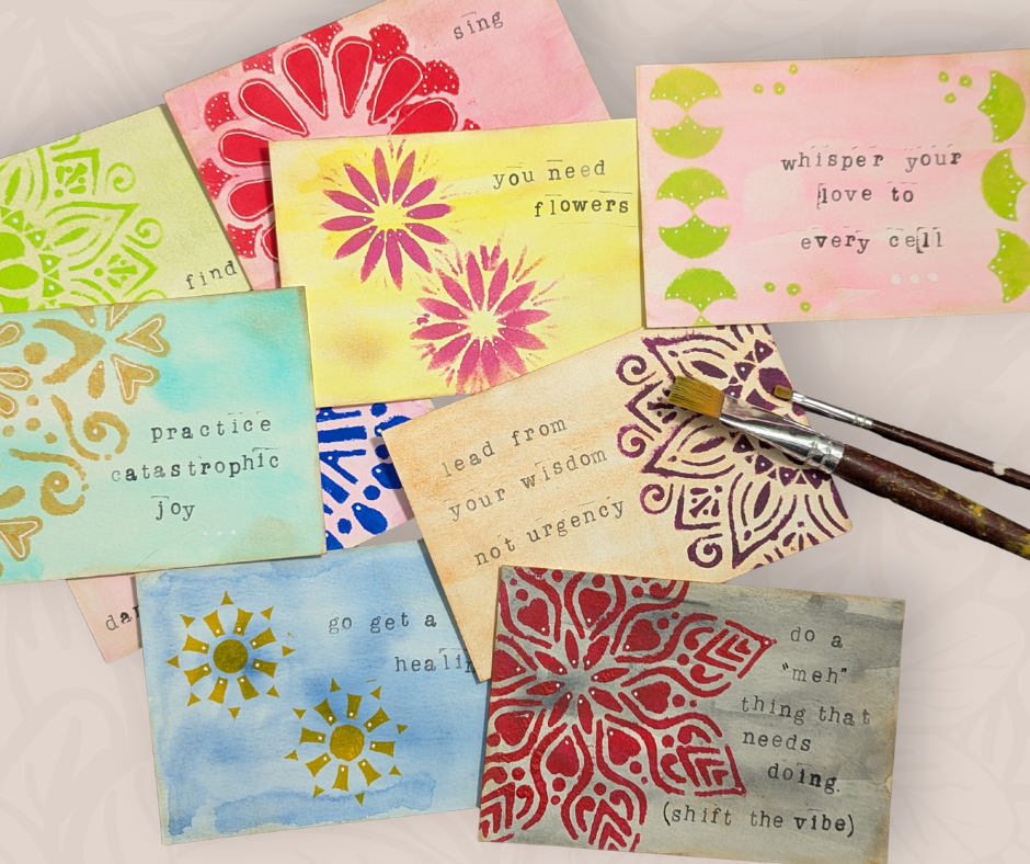 Small handmade art cards with stenciled patterns and simple messages, arranged on a table with a paintbrush.