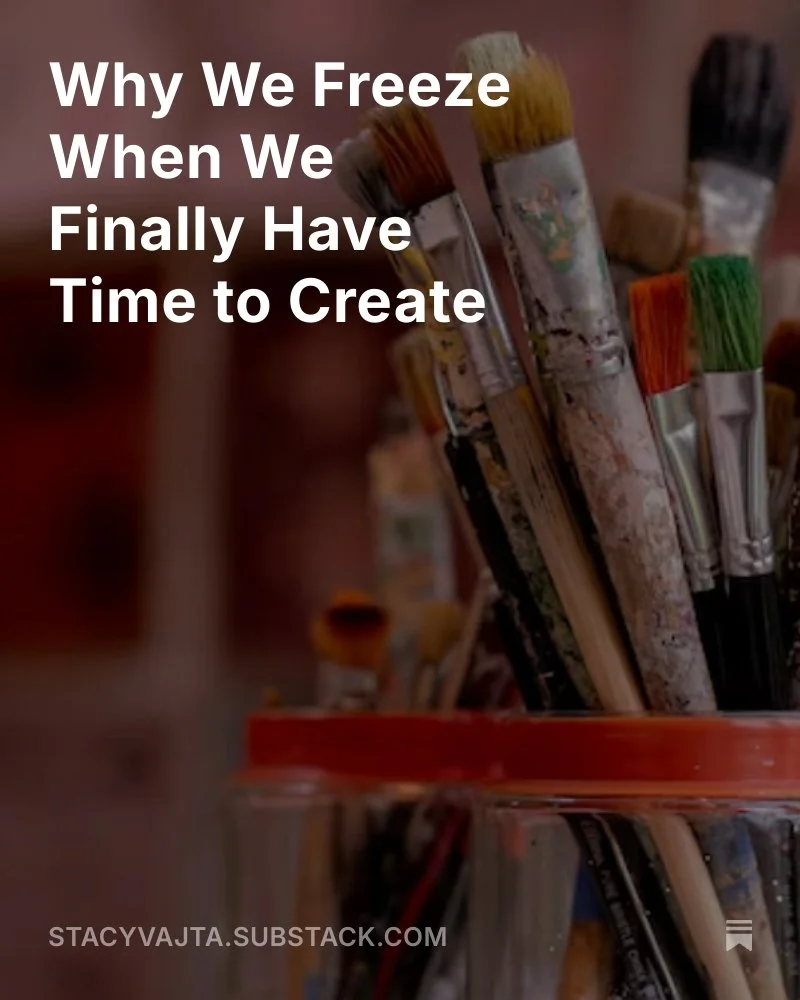 A close-up of paintbrushes in glass jars with the title “Why We Freeze When We Finally Have Time to Create” overlaid on top.