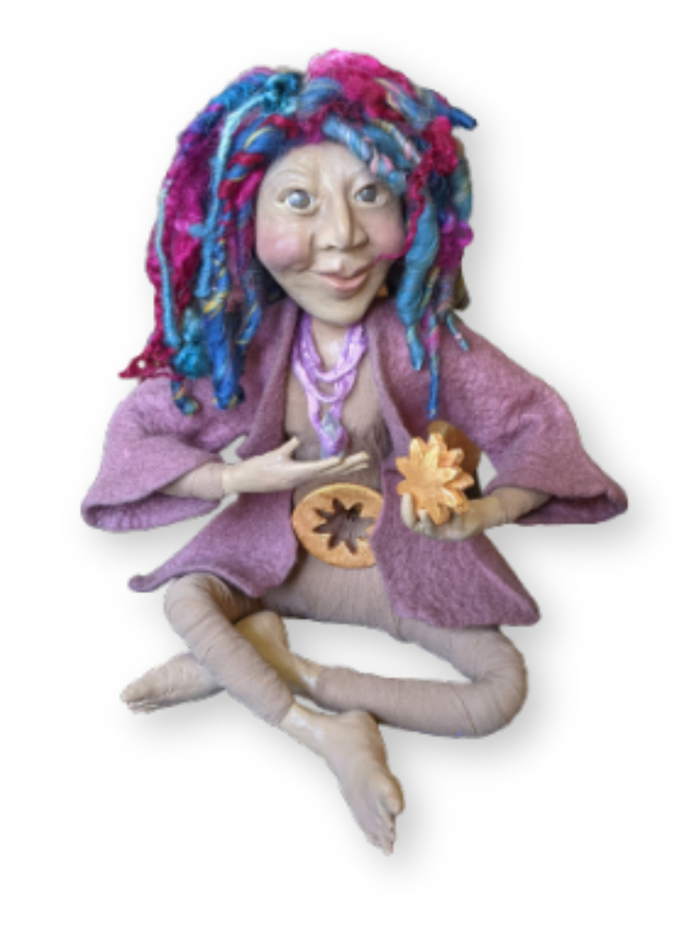 Seated handmade spirit doll with bright blue and magenta yarn hair, a purple jacket, and small autumn-inspired symbols held in her hands.