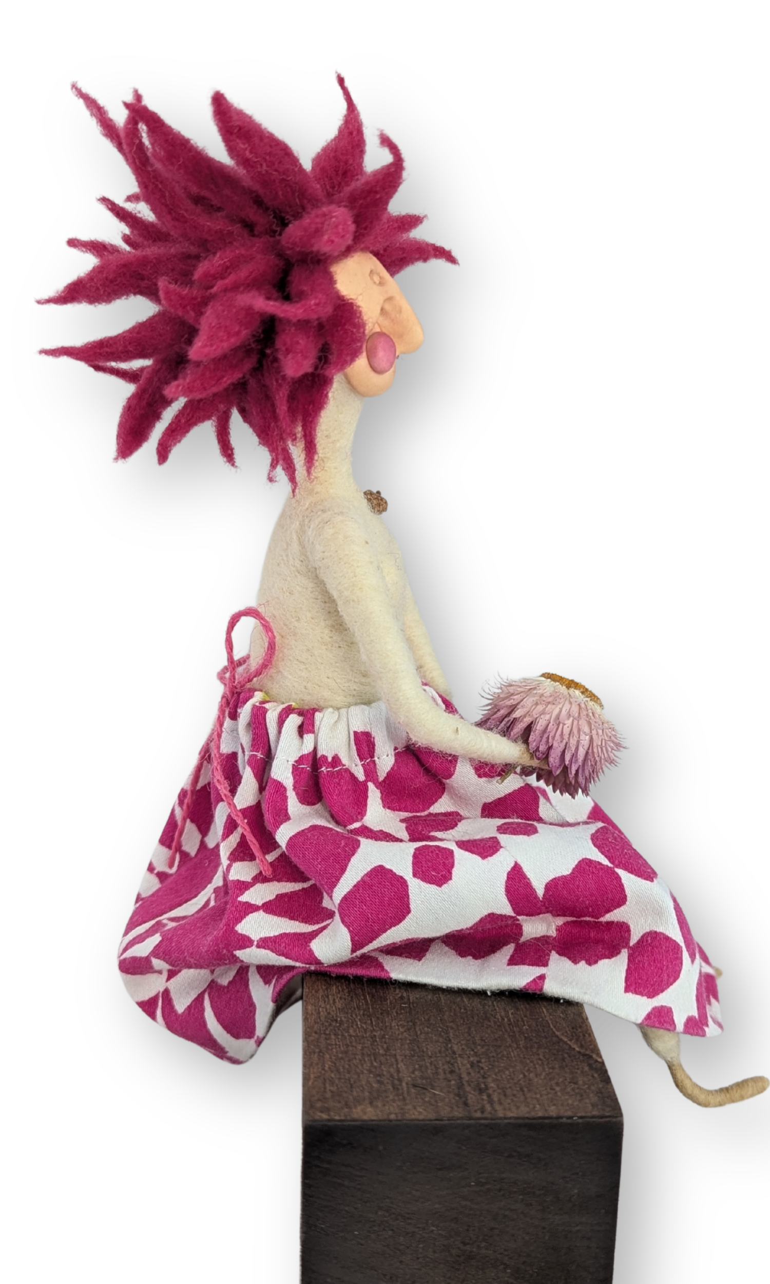 Side profile of Flower Power Guardian Doll, showing her wild pink wool hair and flower skirt from a handmade needle-felted design.