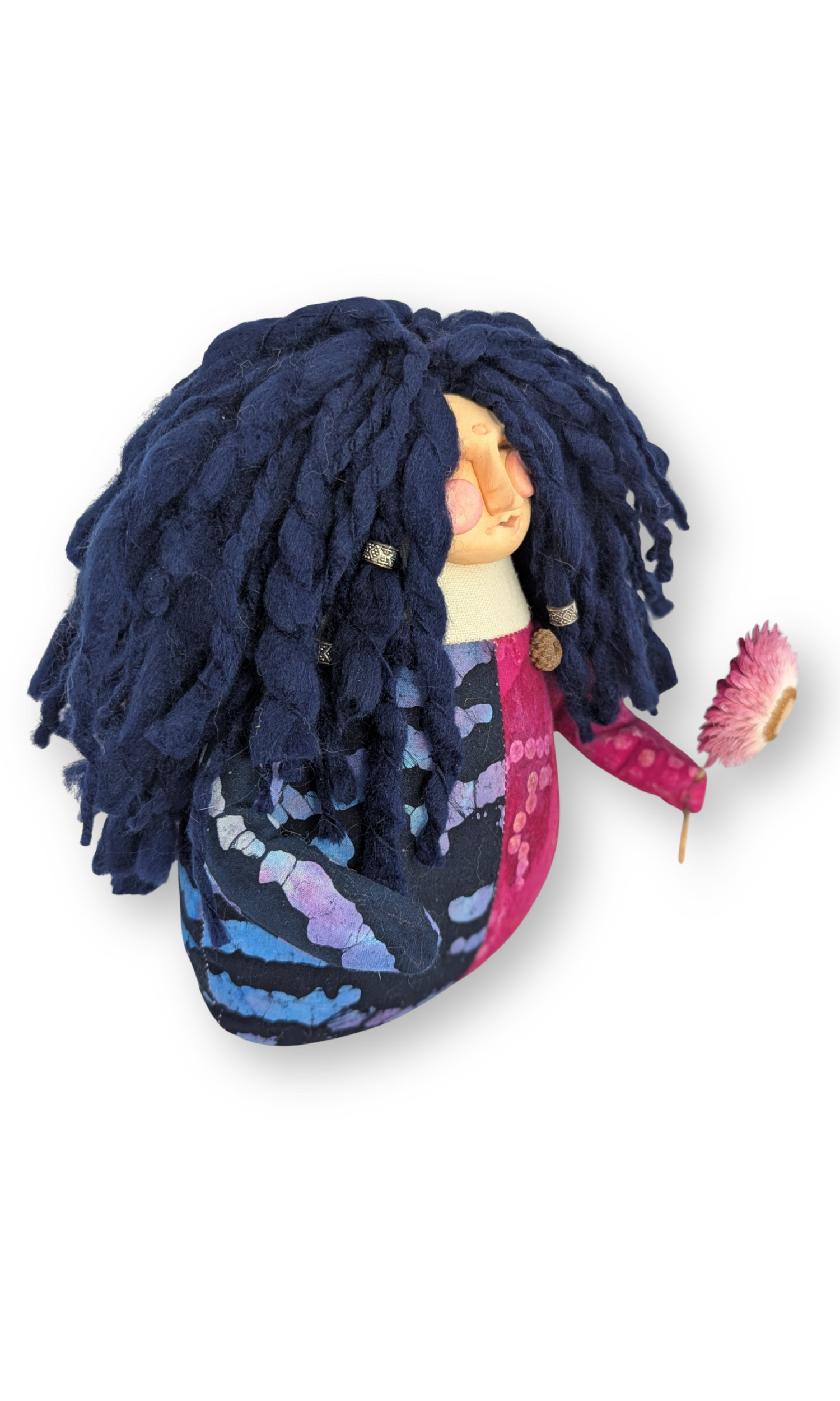 Side view of The Laughing Poppet Guardian Doll showing her two-toned fabric body and flower in hand.