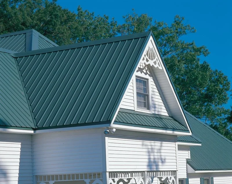 Blue metal roof with standing seam design against a clear blue sky.