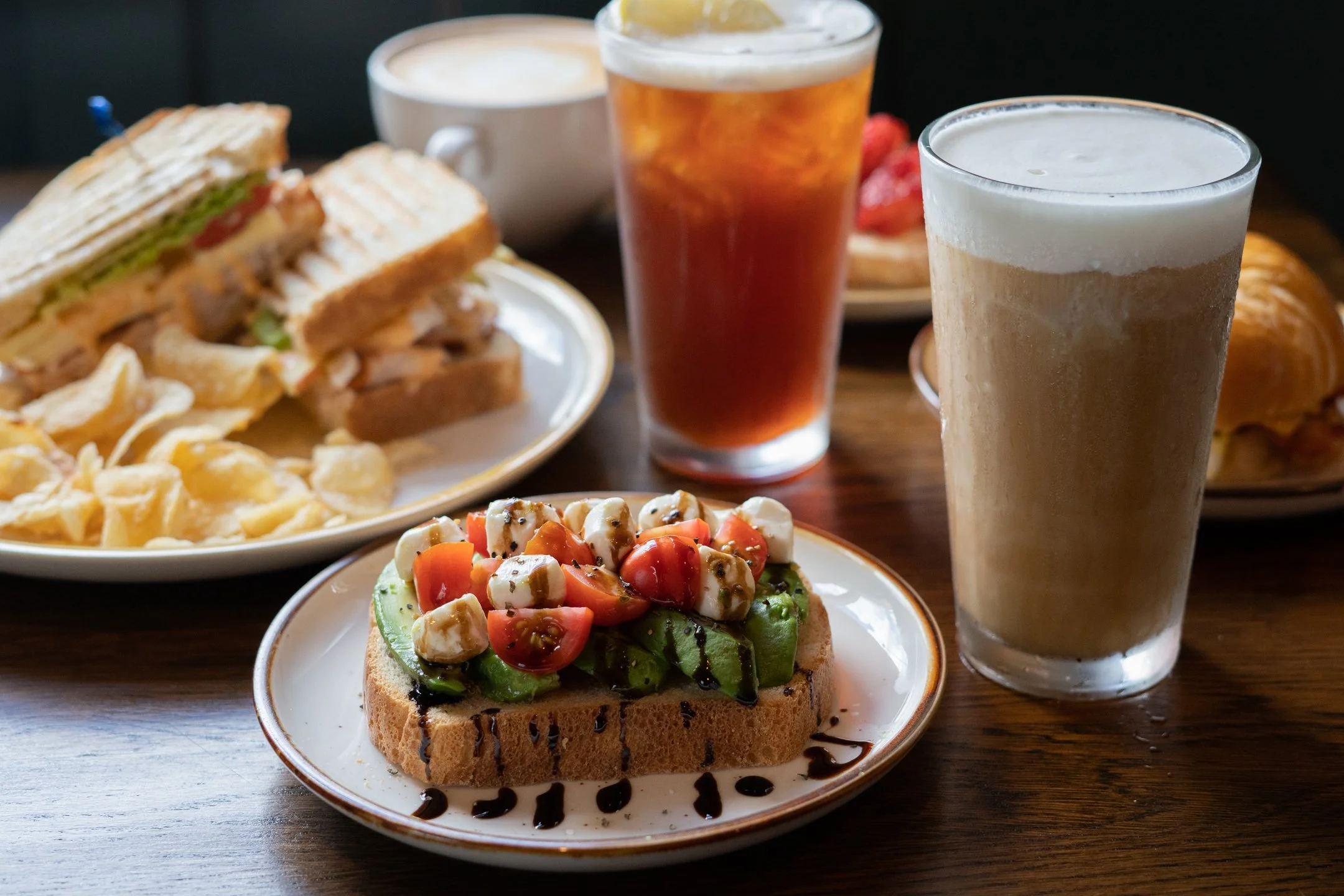 A table spread of plates of food and drinks.