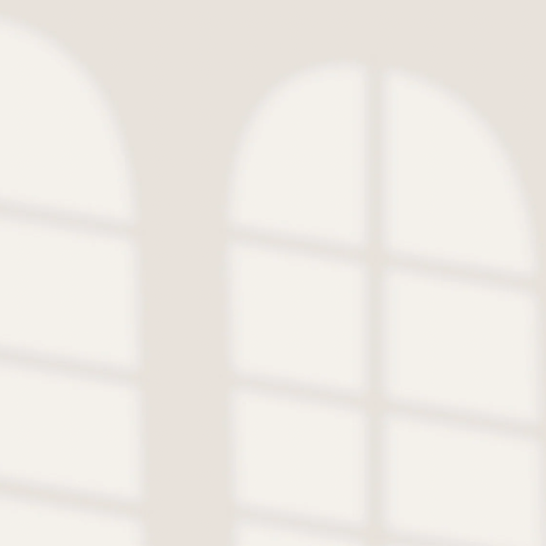 Blurred window with arched panes and sunlight streaming through.