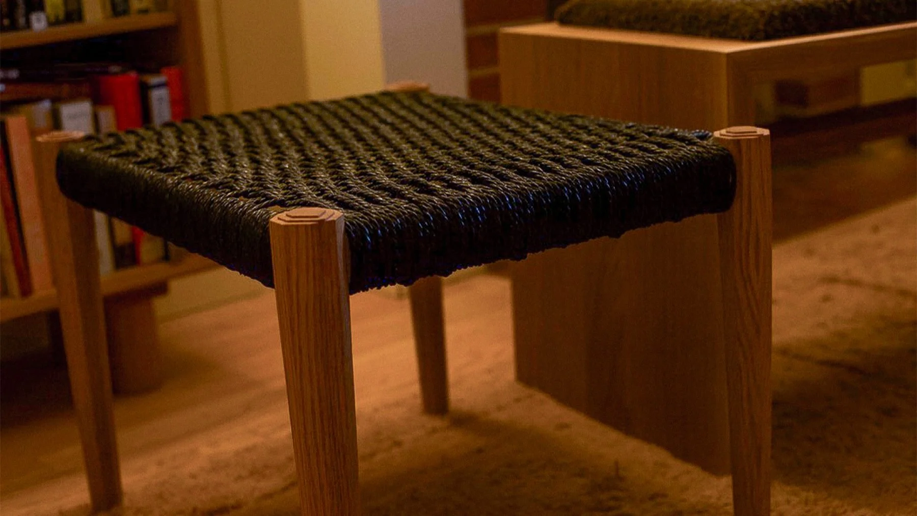 Woven footrest next to the three craters bench. The stepped detail on top of the legs give it a subtly southwestern look without beating you over the head with it. This footrest works well as a side table or even a low seating option in a pinch. Thre
