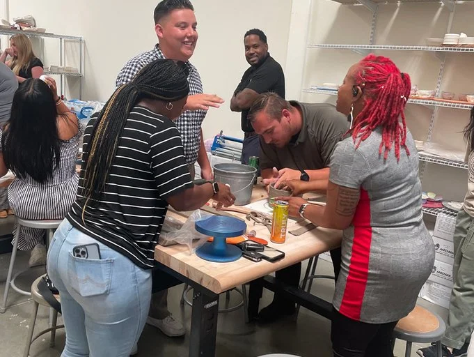 Mud Hut Pottery Studio offers Team Building Activities like the one pictured here.  Supplies and tools, including clay and a pottery wheel, are visible.