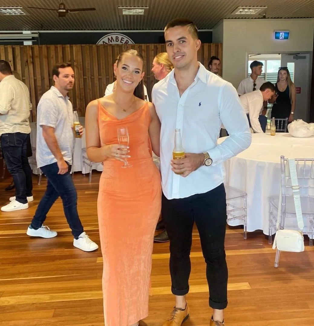 Couple posing with drinks at a social event