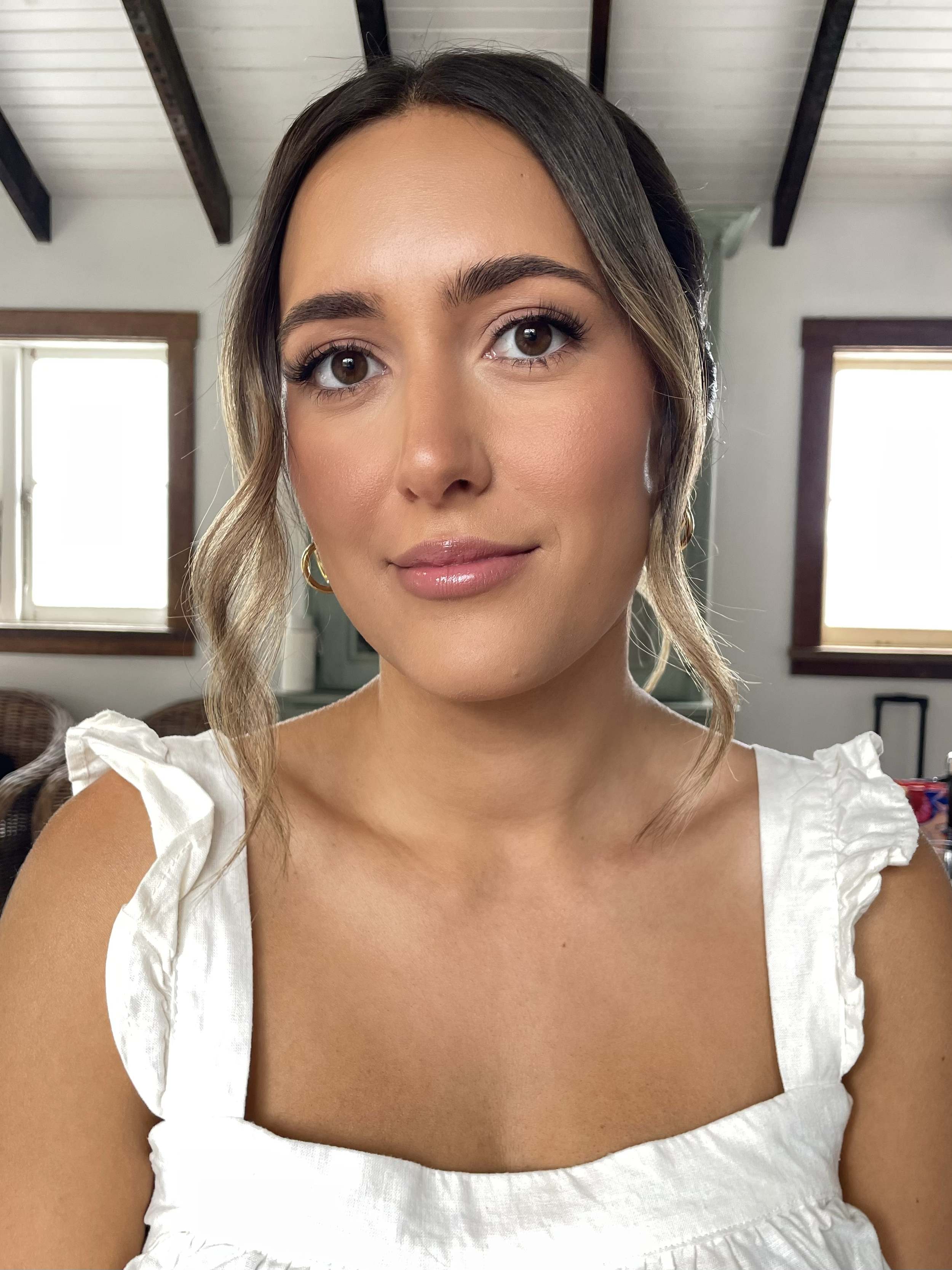 Woman in a white top with ruffled sleeves in a room with exposed beams.