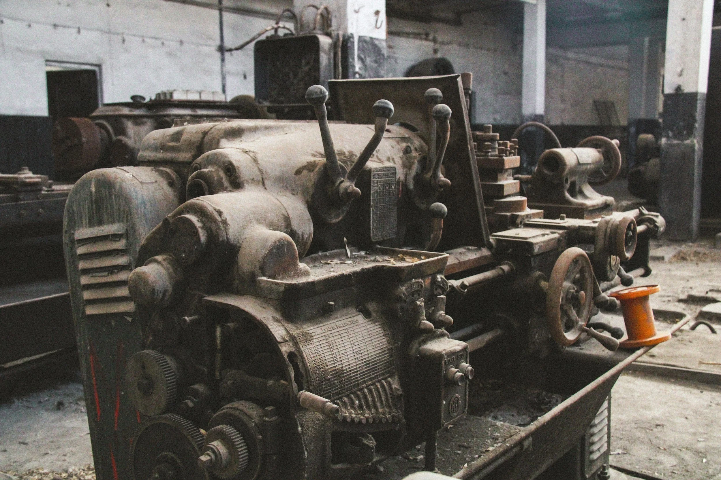 Rusty vintage industrial machinery with levers and gears in an old workshop