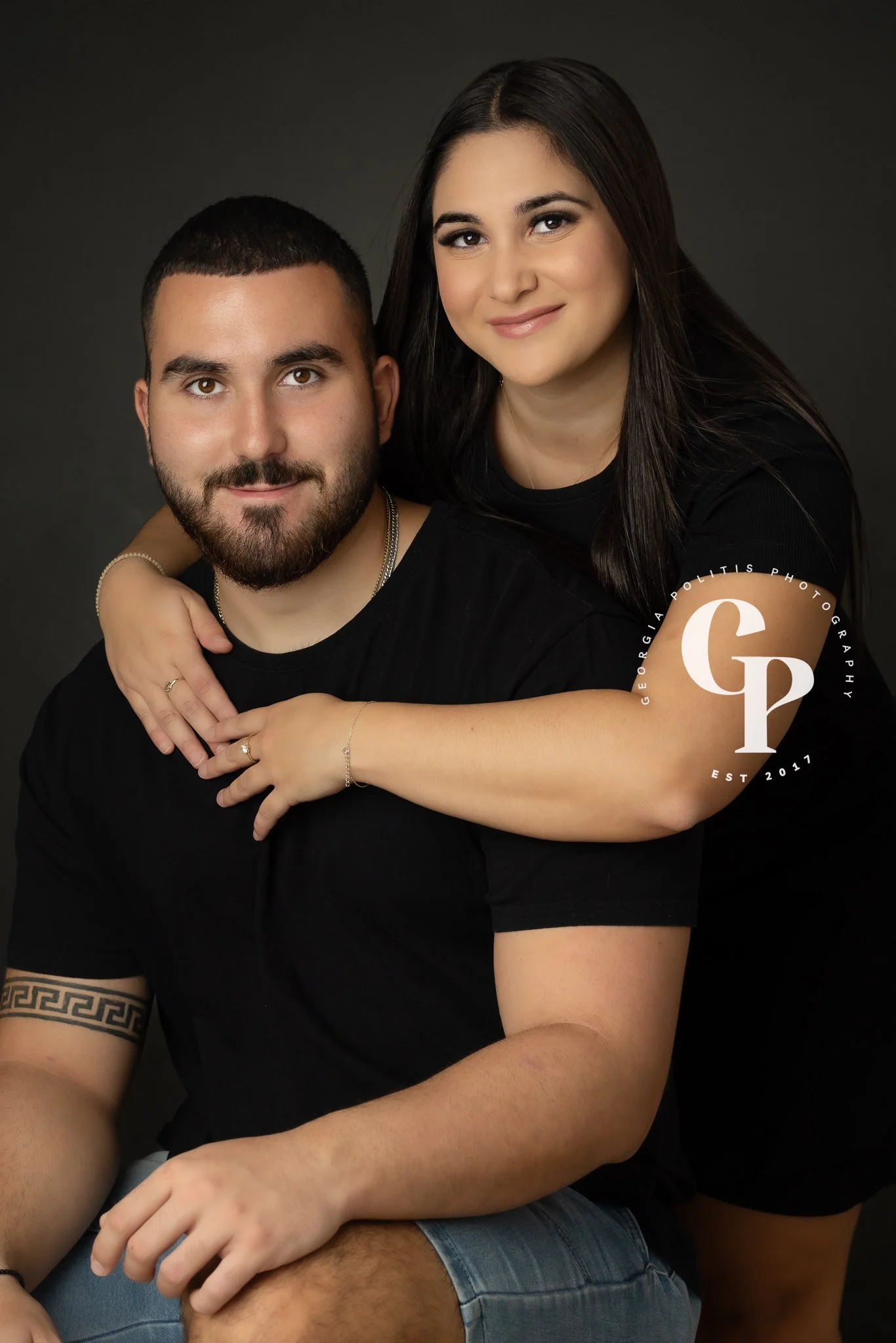 A Darwin Couple in a professional studio photography photoshoot with black outfit and backdrop