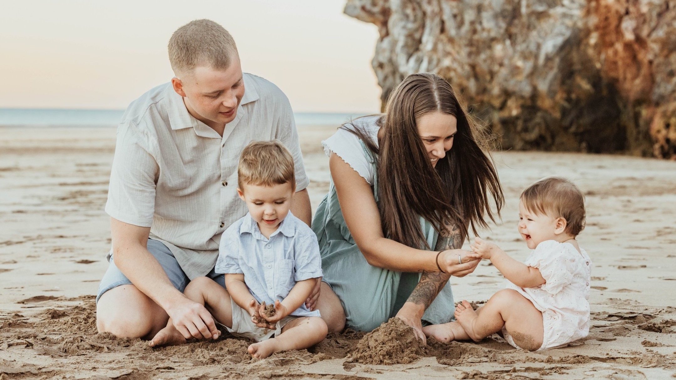 A Darwin family enjoying sand play at the beach during a photoshoot