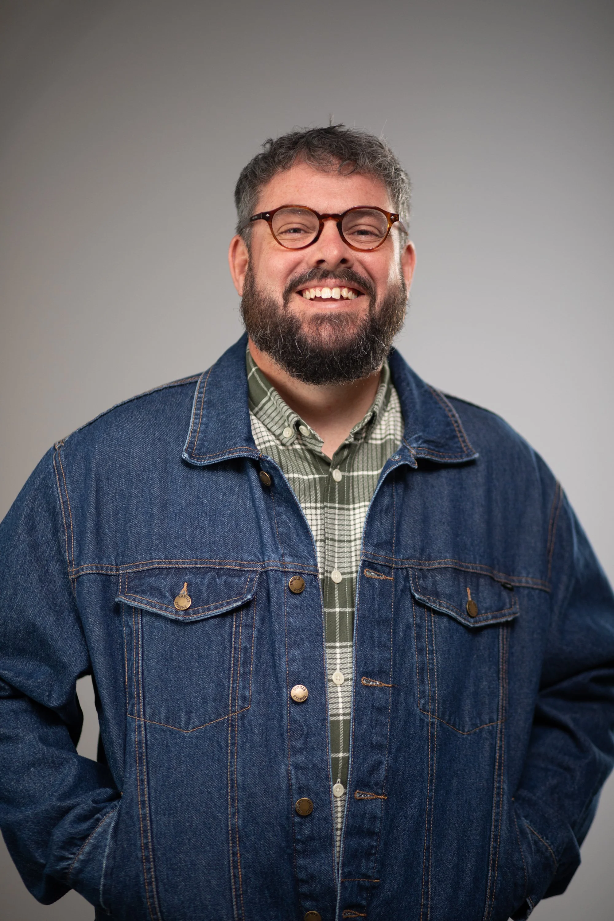 Man with glasses and a beard smiling