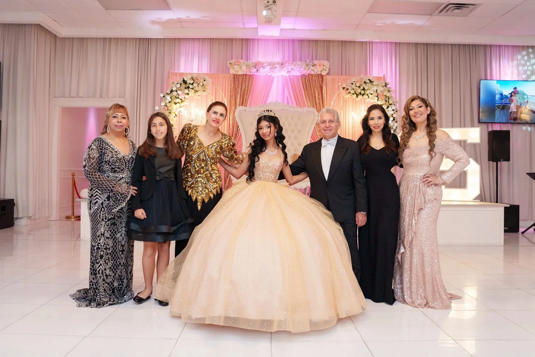 Quinceañera in a gold gown with her family at a Fort Worth reception