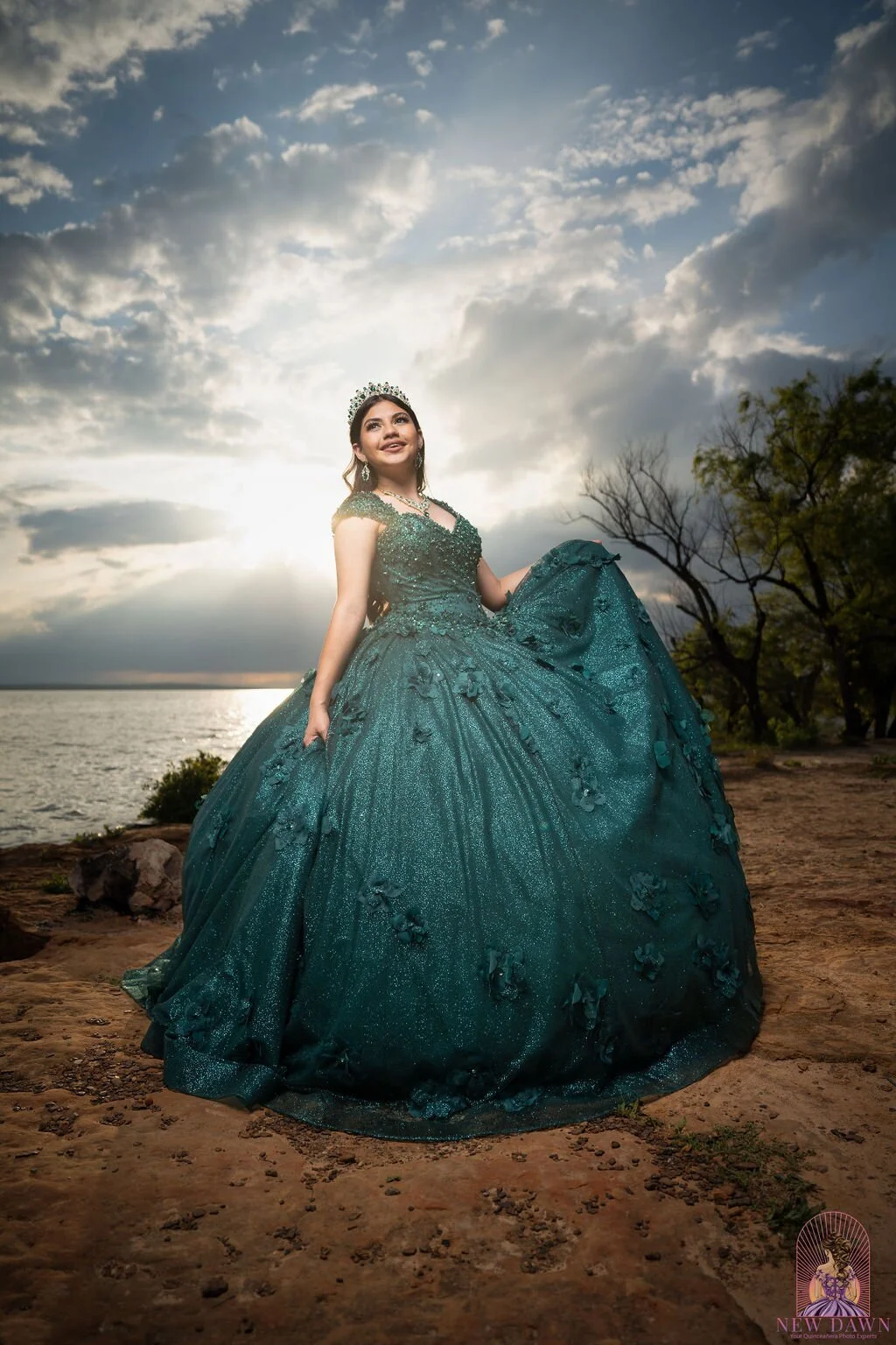 Retrato cinematográfico al atardecer de quinceañera con vestido esmeralda y silueta de árbol sobre el lago Grapevine, Flower Mound, TX