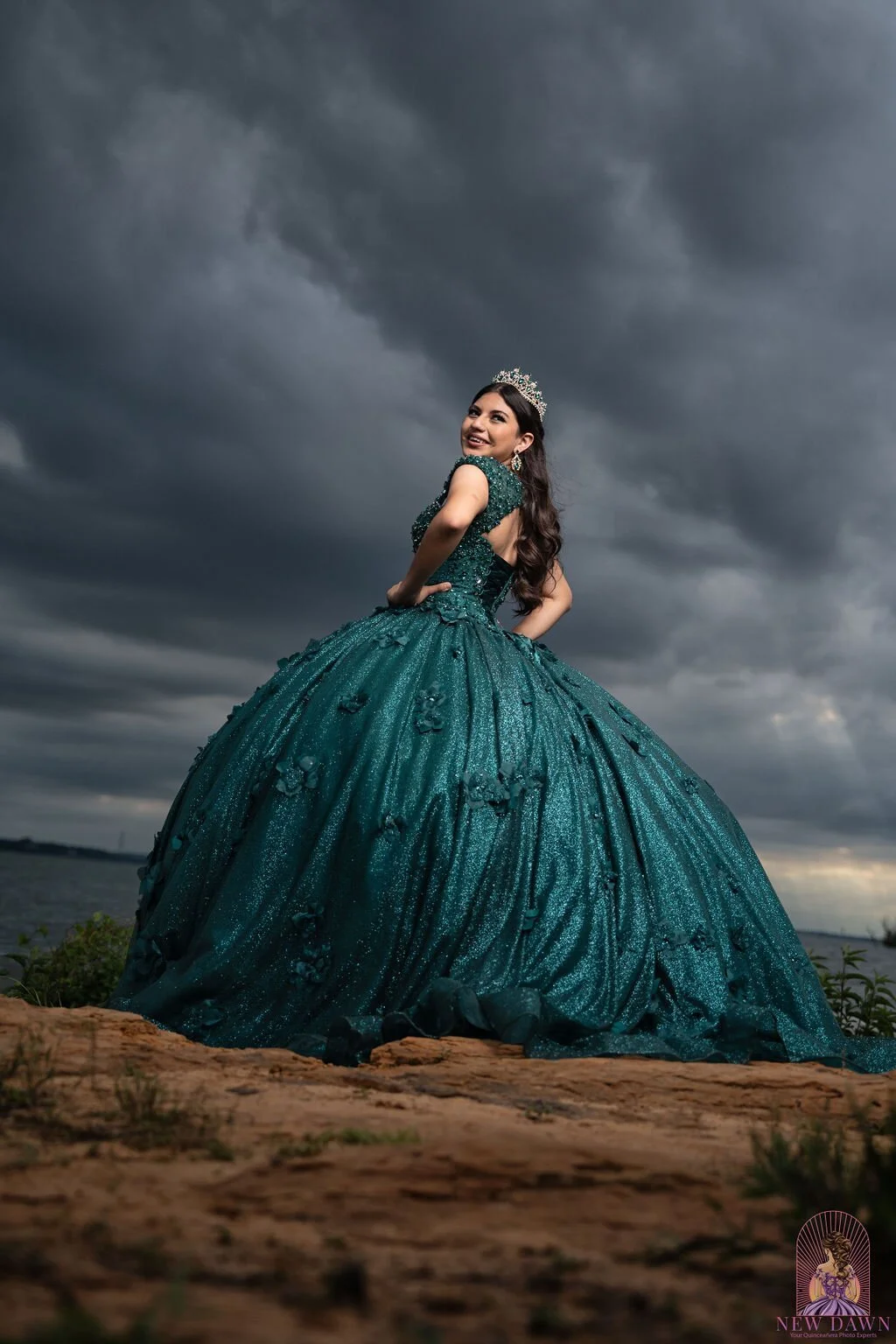Retrato en ángulo bajo de quinceañera con vestido esmeralda sobre un afloramiento de arenisca con nubes de tormenta, Murrell Park en el lago Grapevine