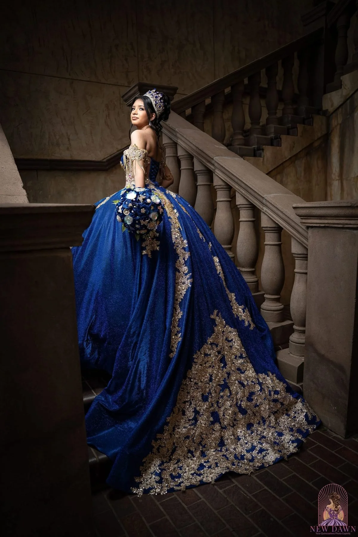  Quinceañera in royal blue and gold gown on a baroque carved staircase at a Las Colinas venue 