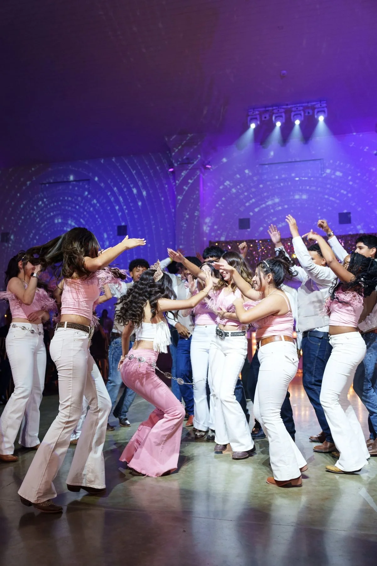 Quinceañera surprise-dance choreography with court in pink tops and white pants at DFW reception