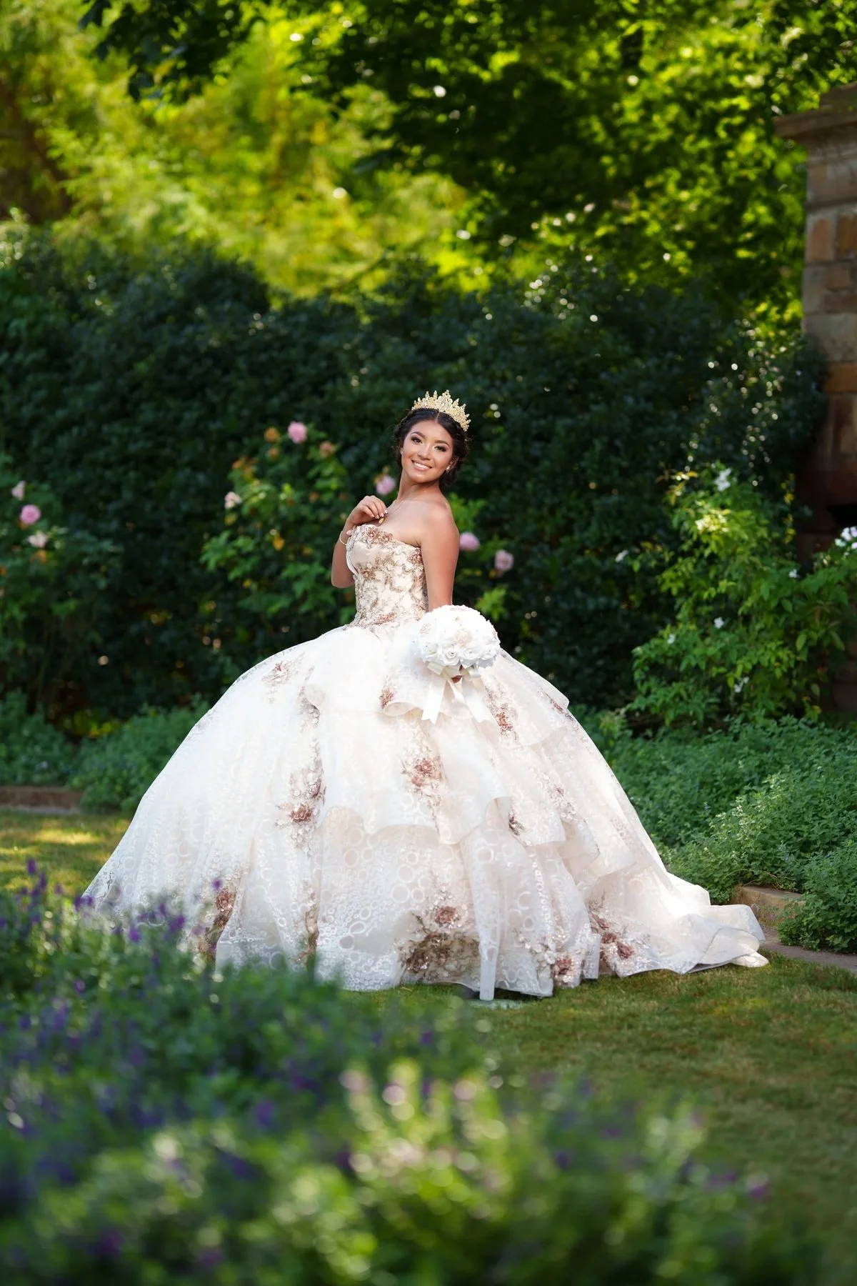 Quinceañera in champagne and ivory gown with rose-gold floral embroidery in a garden of roses and lavender in DFW