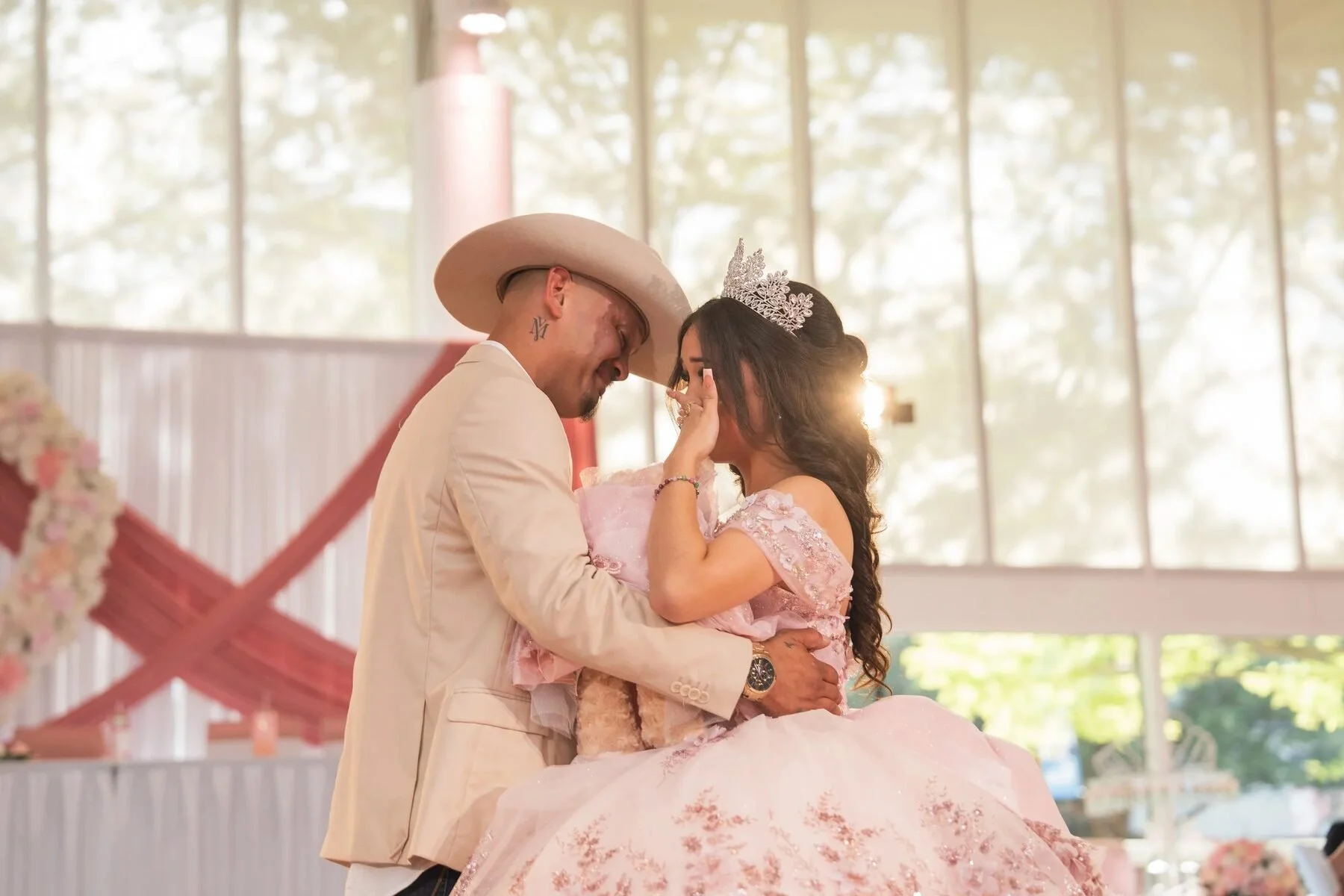 Father in a cowboy hat shares an emotional embrace with his daughter at a Fort Worth quinceanera.