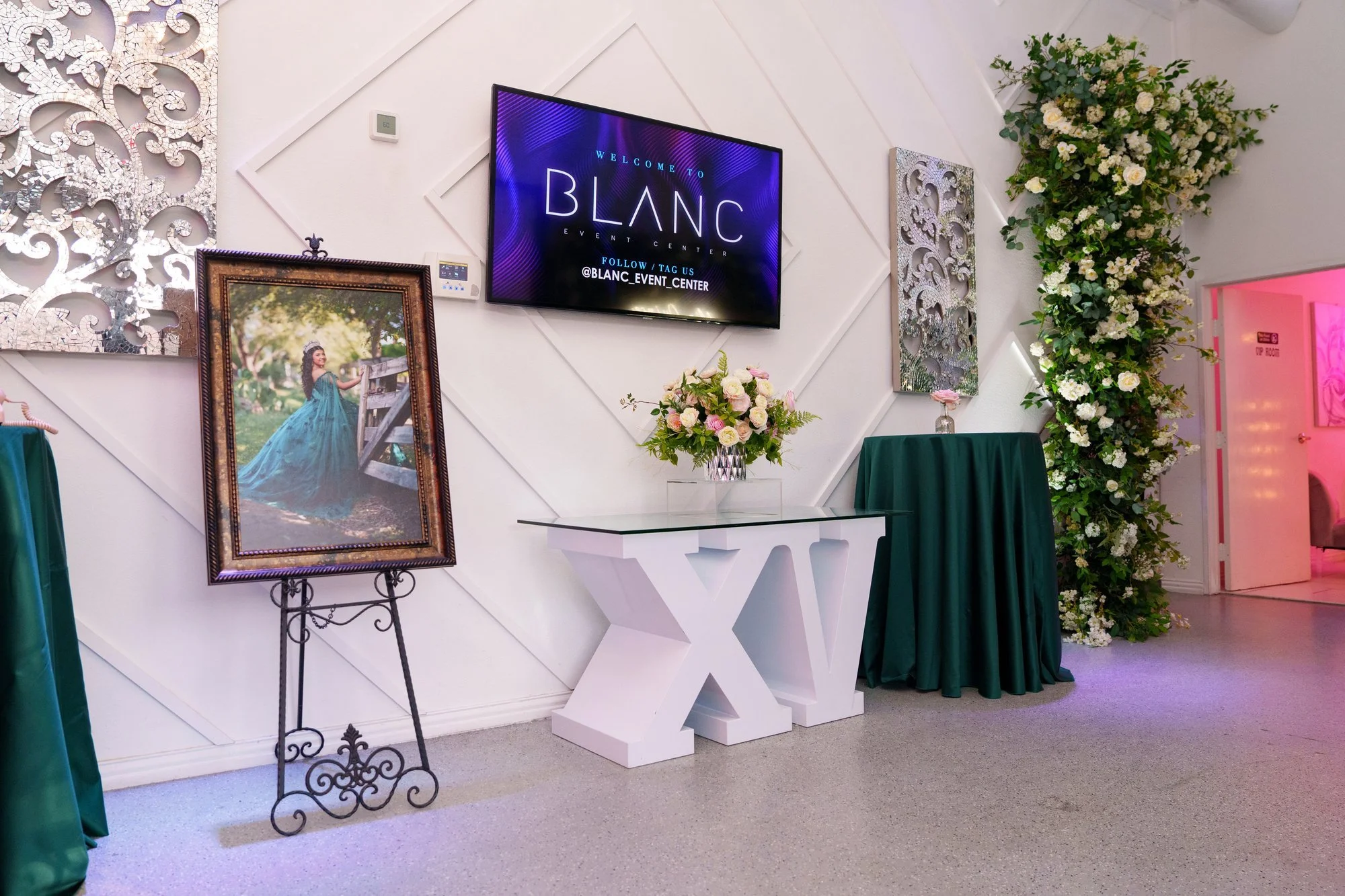 Entrance to Blanc Event Center in Dallas featuring the Blanc logo sign and elegant green-draped guest reception area