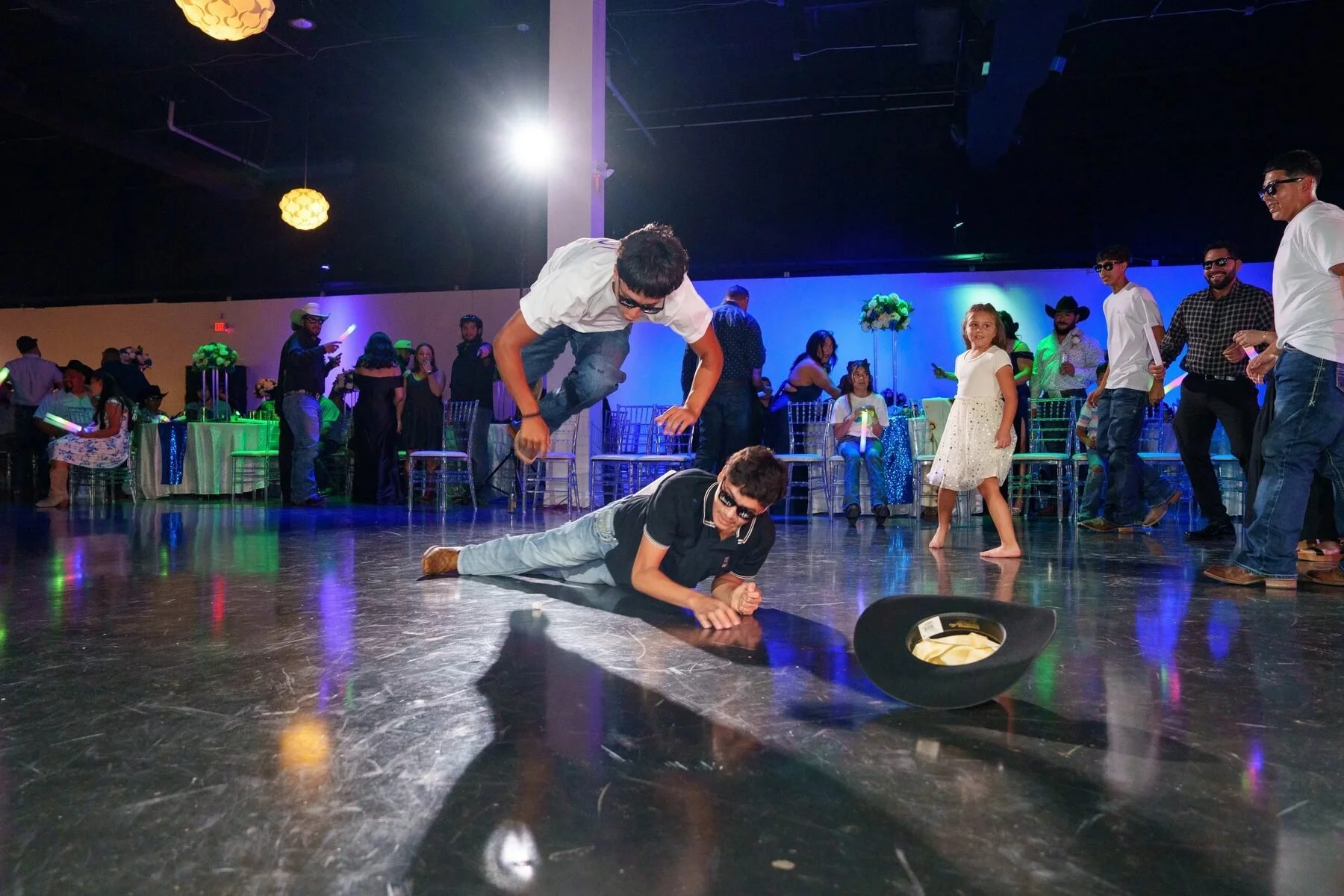 Guests playing a lively hat game on the dance floor at a Dallas quinceañera