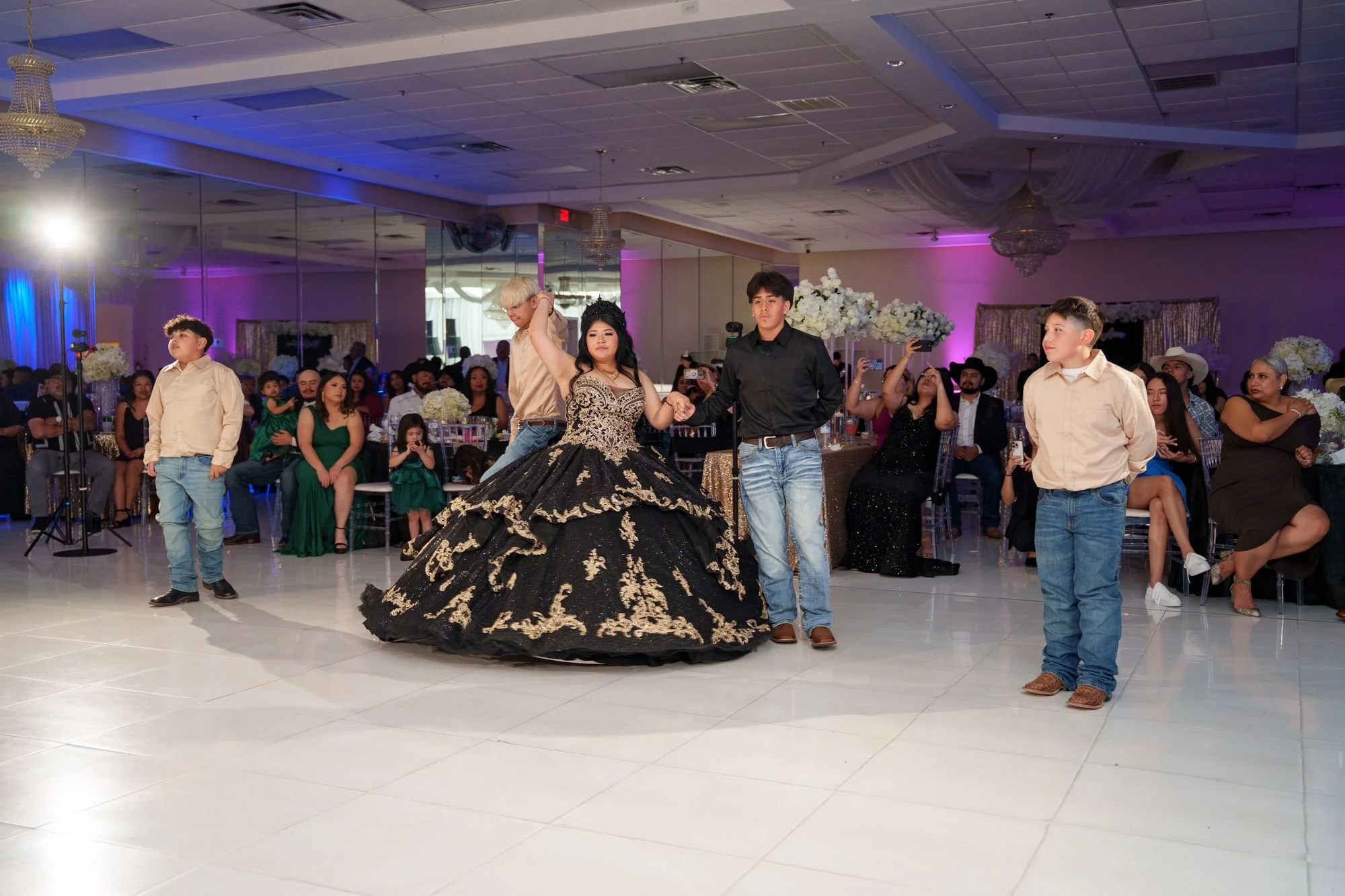 Jayden spinning with her chambelán de honor during her quinceañera opening court dance with seated guests watching at Luxor Banquet Hall Carrollton TX