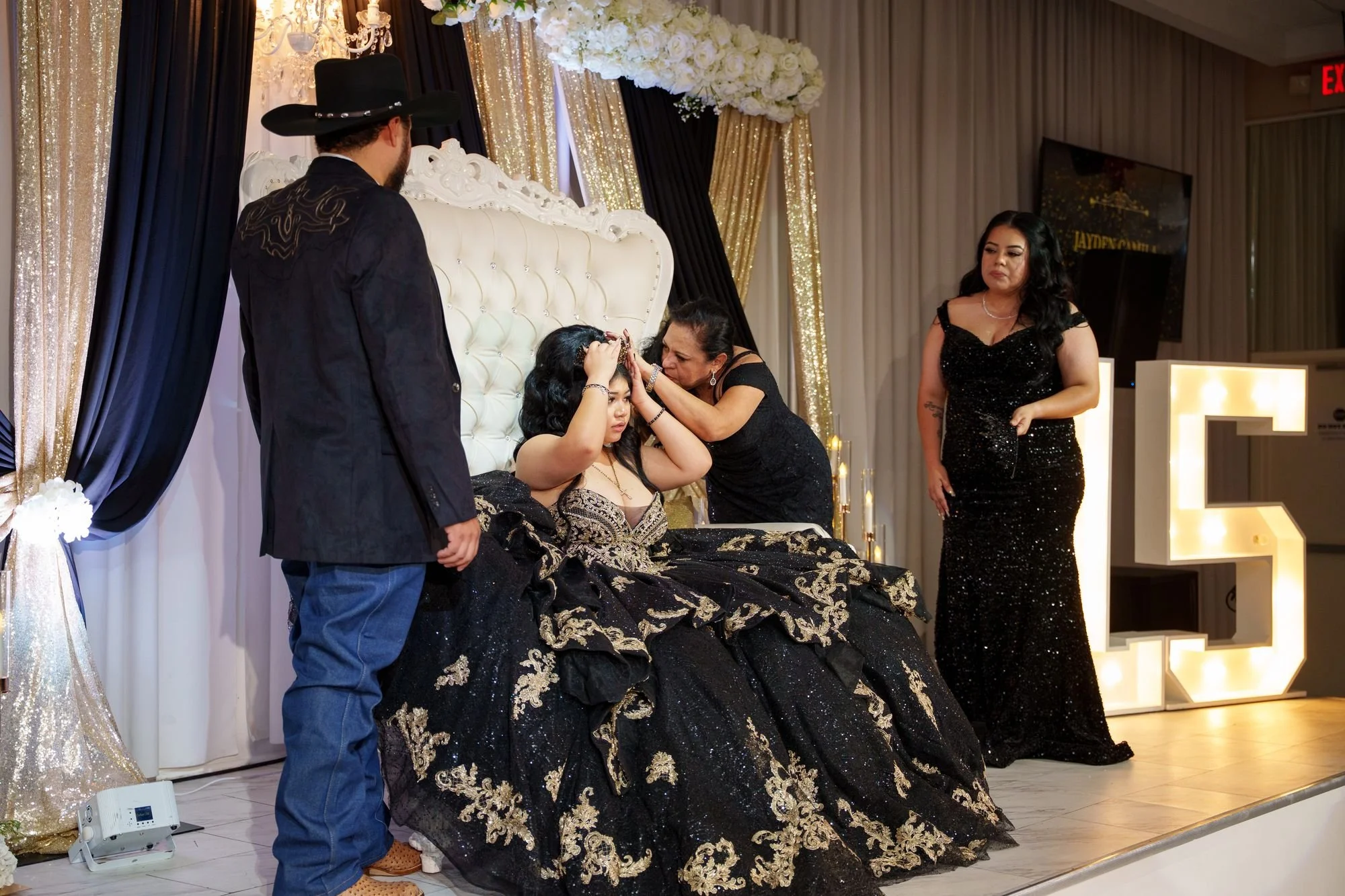 Grandmother placing crown on Jayden's head during traditional crowning ceremony with father watching at her quinceañera at Luxor Banquet Hall Carrollton