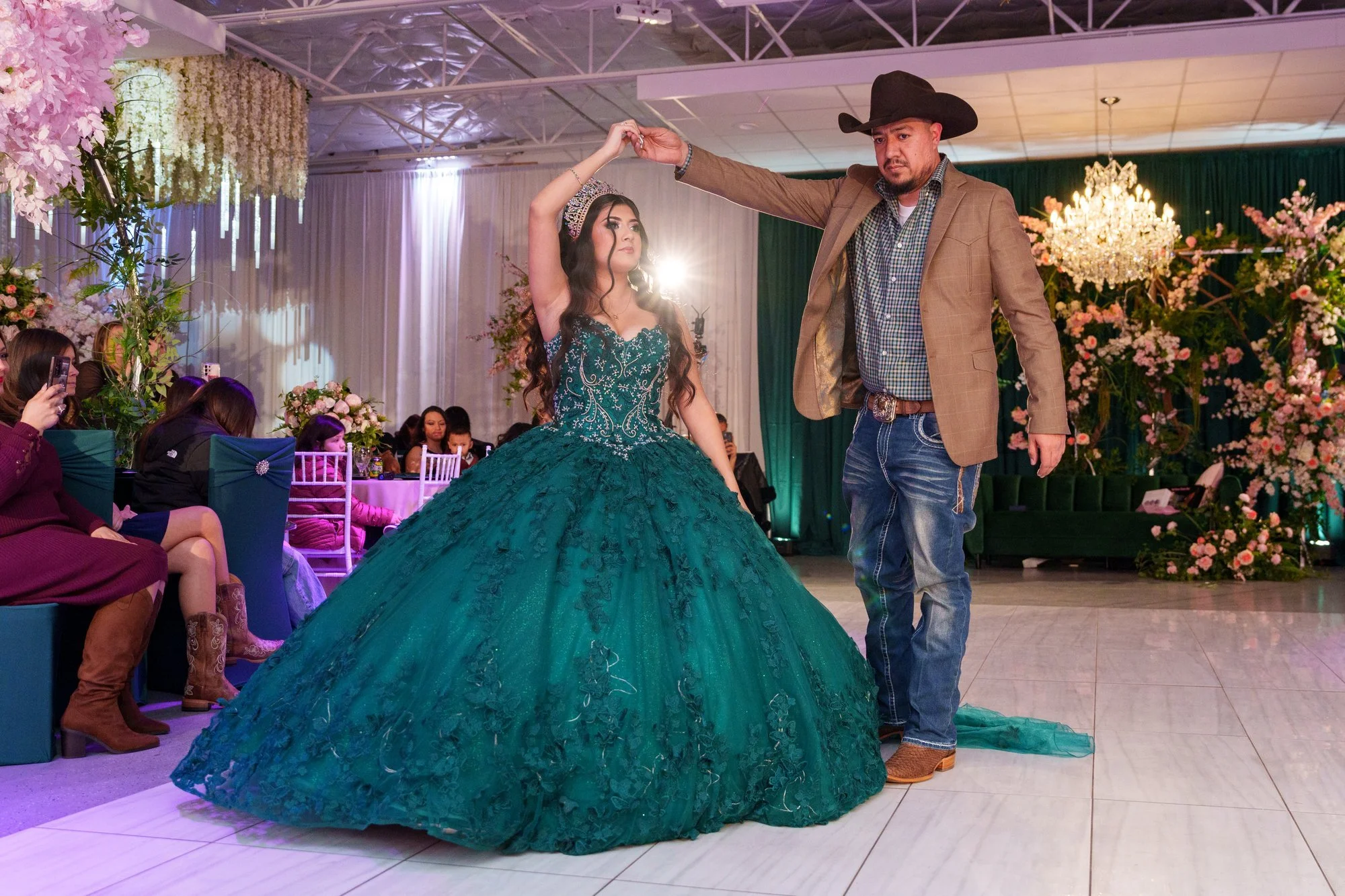 Nevaeh spinning on the dance floor with her father in a cowboy hat during the father-daughter dance, dramatic fog at their feet