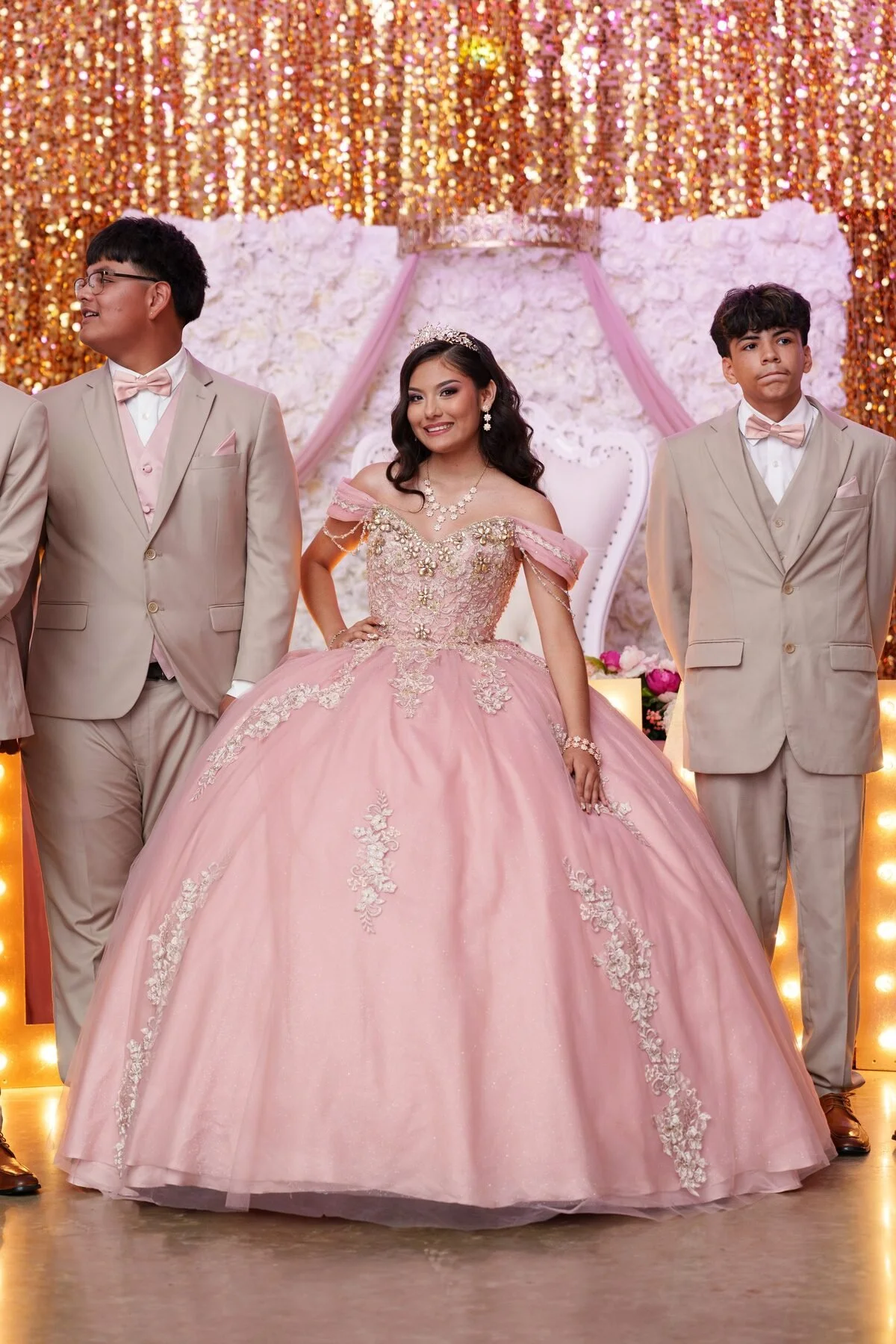 Quinceanera in a rose-gold gown stands with her chambelanes at a Fort Worth reception.
